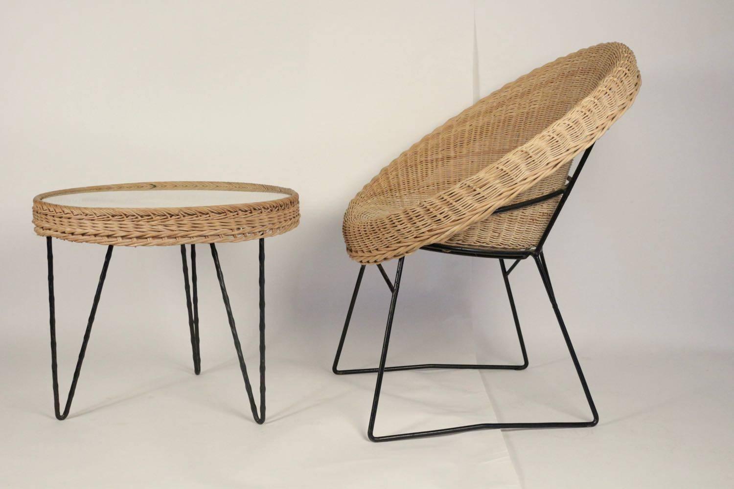 1950s rattan lounge set attributed to Mathieu Matzot.
Consisting of four wicker chairs, with conical removable shell, the black iron rod legs nicely emphasizes the structure.
One coffee table, with a rattan tray protected by a glass frame, graphic