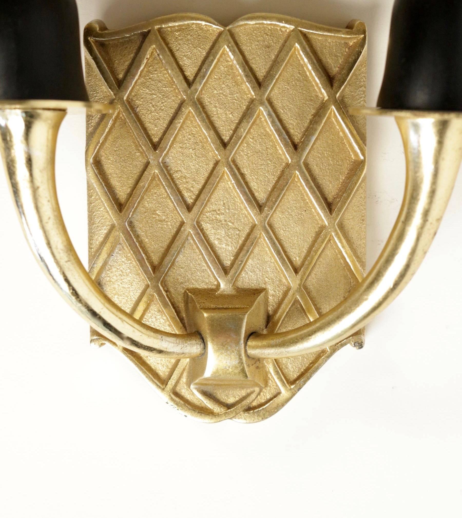 Pair of sconces, Maison Petitot, 1950.
 
The pair consists of backplate in shape of shield in gilded alloy on which two arms are ended by half moon lampshades made of black cotton and gilded inner face.

 