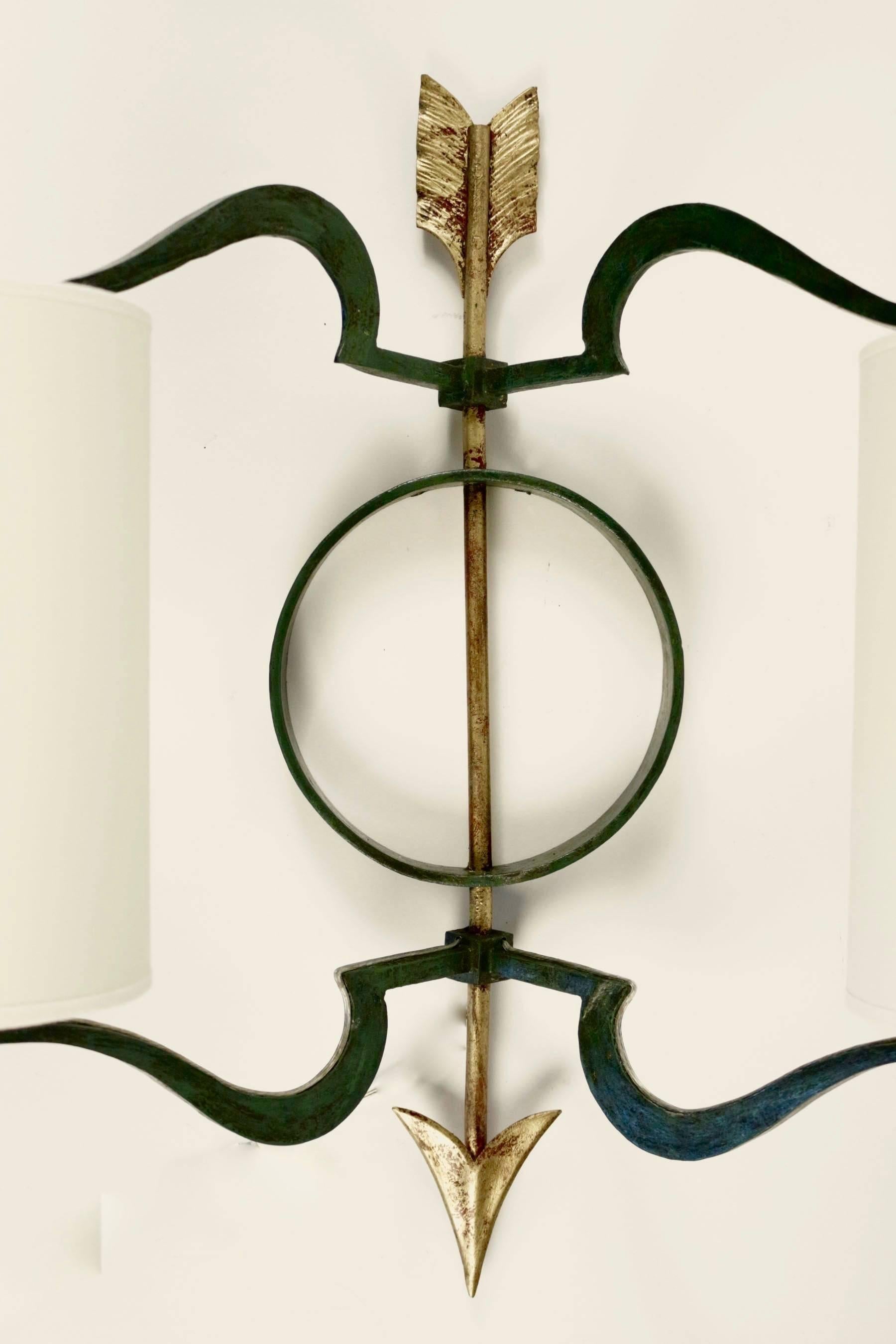Large Arrow pair of sconces, Jacques Tournus, circa 1951

Each sconce is composed by one central gilded bronze arrow which support two cylindrical lampshades in white ivory cotton.

The arms are half heart shaped in verdigris bronze. The central