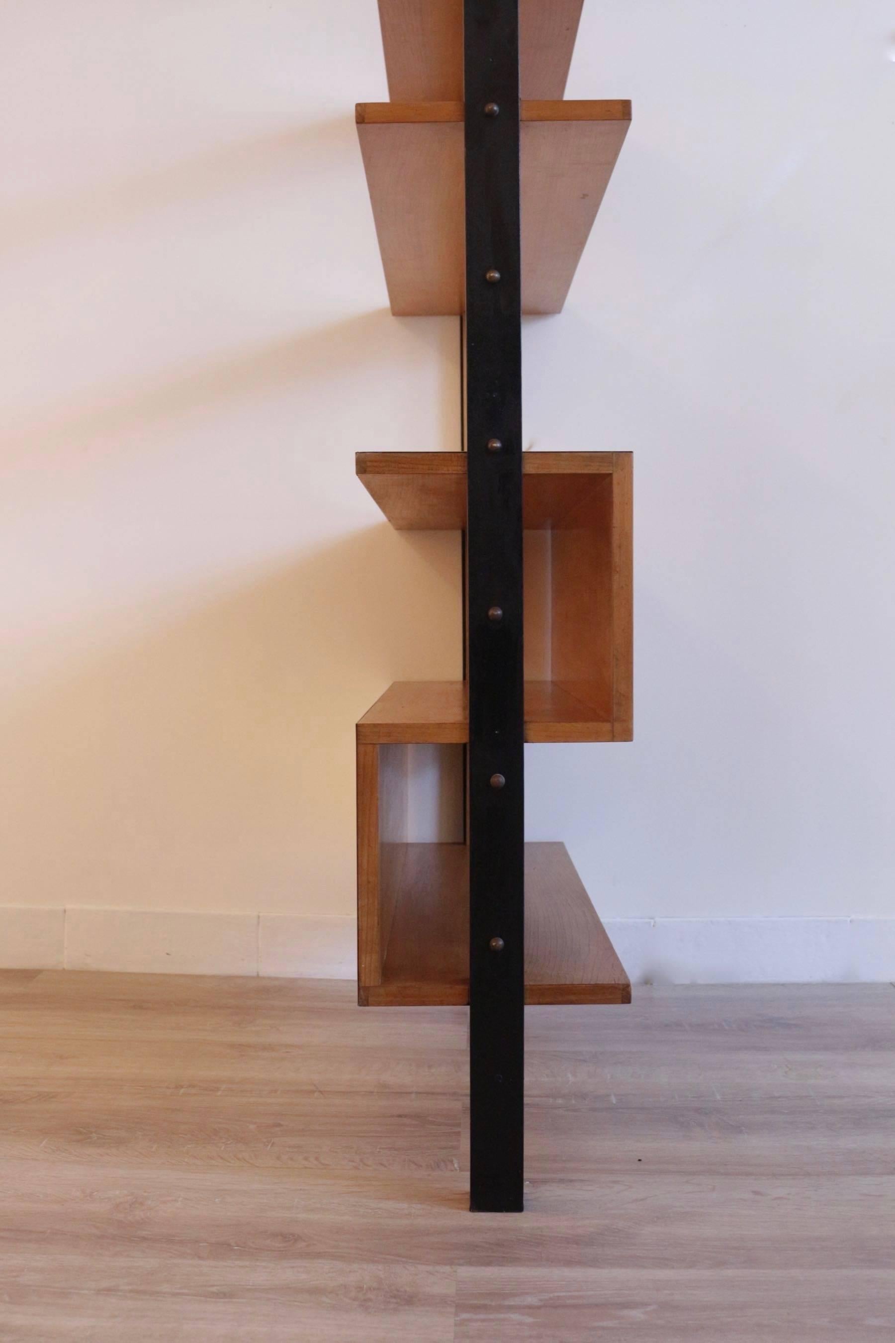 1950 cherrywood bookshelf  to Pierre Guariche.

Free standing bookshelf composed by a large black lacquered steel frame, highlighted with brass cabochons. 

On the upper part, three cherrywood shelves and on the lower part, two storages white
