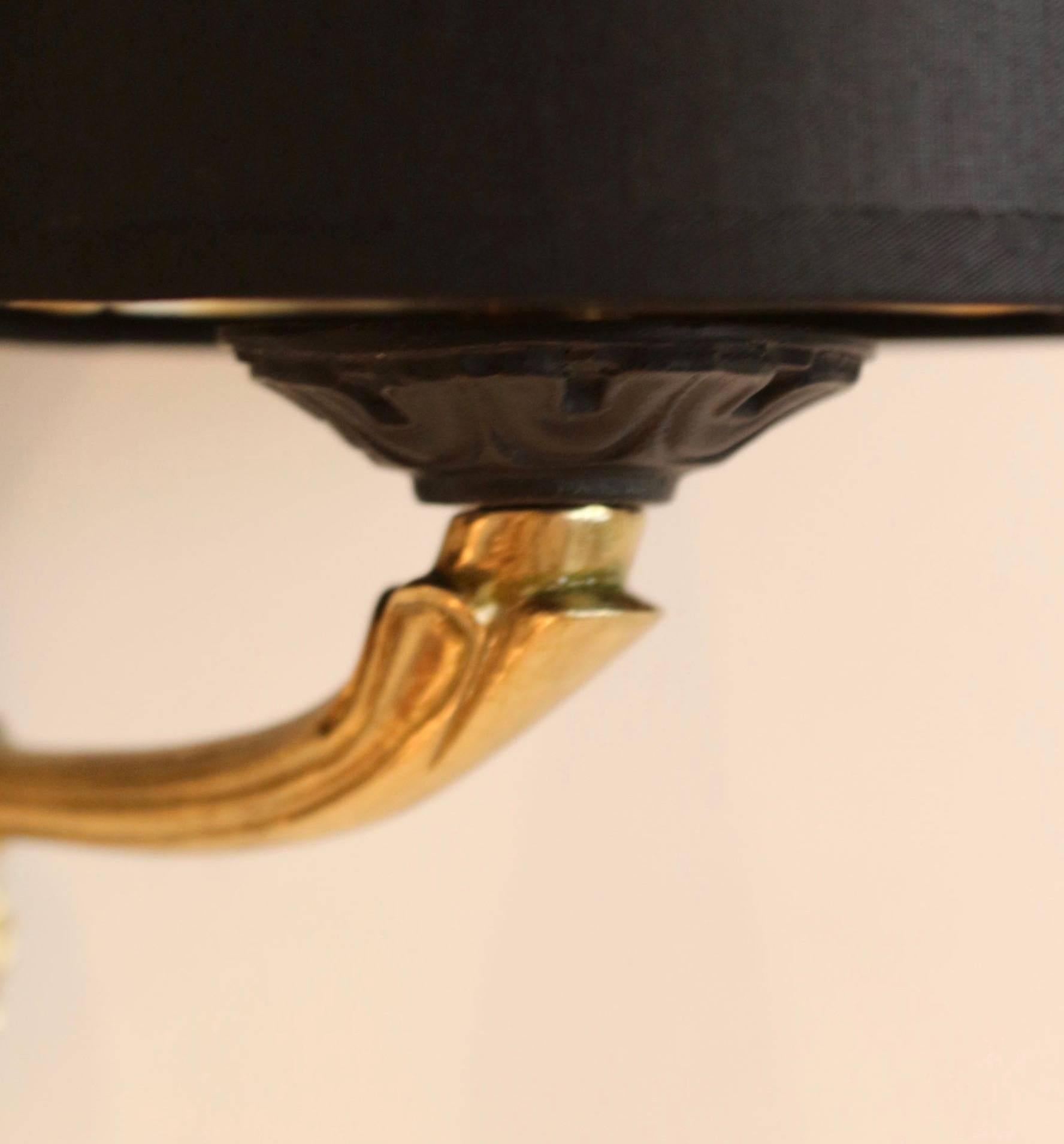 1960s Maison Honoré neoclassical pair of sconce.

Round backplate, black lacquered, adorned with a brass ball, a leaves crown and a star.

Two arms which support two handmade lampshades made of black cotton and gilded inner face, granted to the