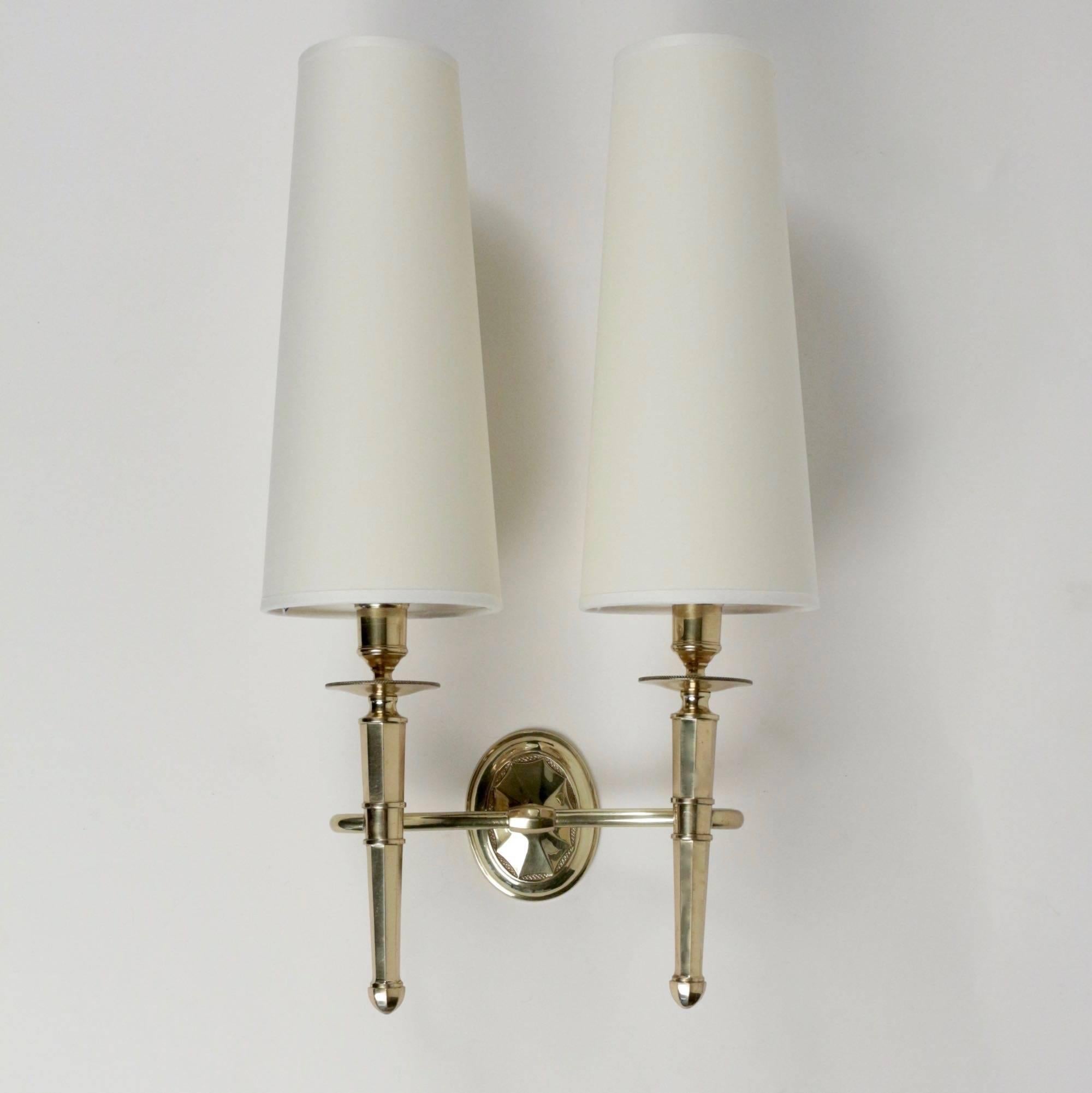 1950s set of three gilded bronze sconces by Maison Honorée.

This set of "Torch" wall light is composed with a pair of double sconce and one triple arms sconce. Round backplate. 

Handmade off-white cotton lampshades. 

Three arms