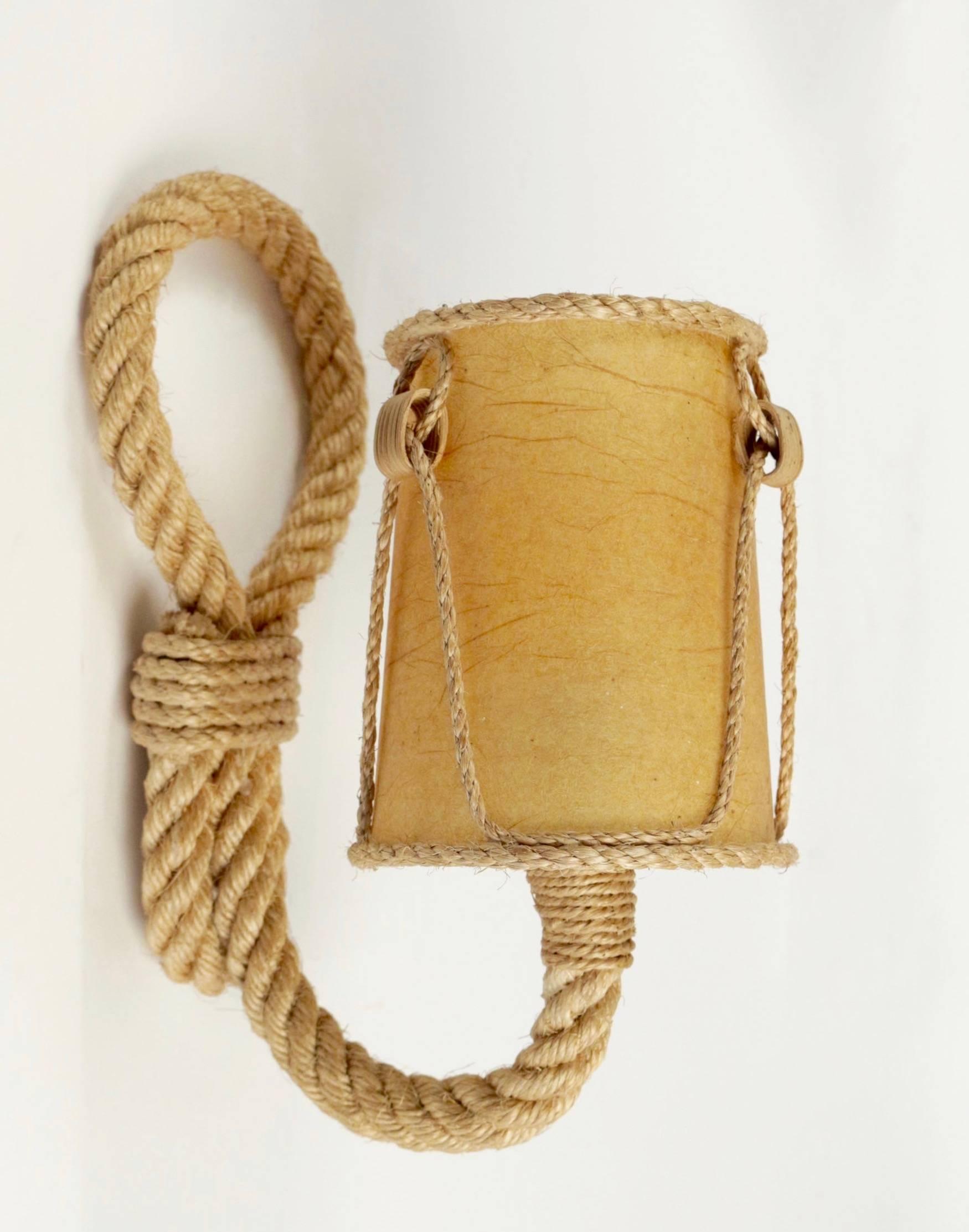 1950s pair of Audoux and Minet rope sconces school of nice.

Each sconce is composed by one buckle and one arm made of rope.
Rare original lampshades adorned with a thin cord motif.

One bulb per sconce.