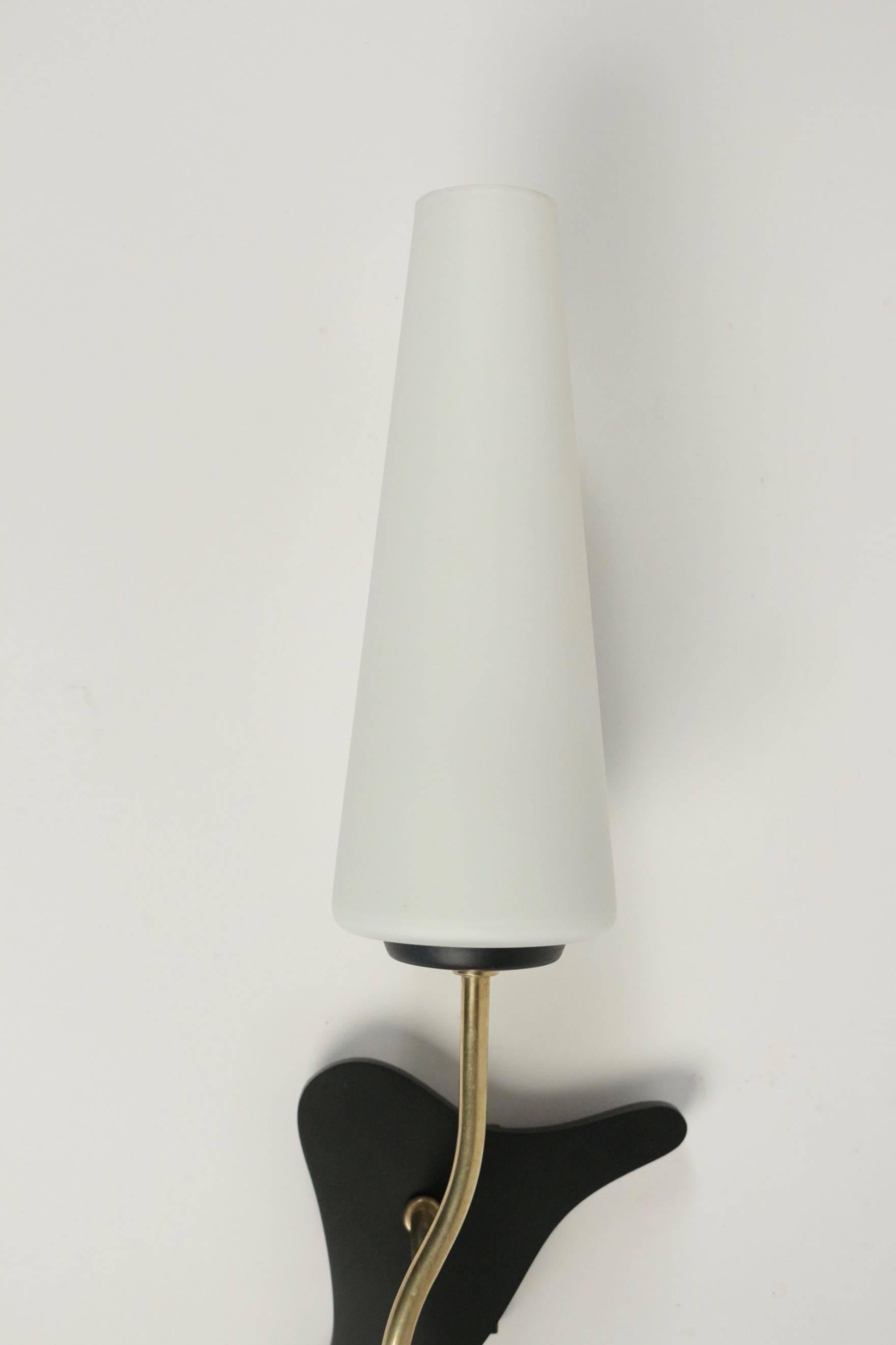 1950s Pair of Arlus Sconces.

The back plates are made of black matt lacquered metal. 
The conical white satine glass lampshade is mounted on curved brass arm.

One bulb per sconce.