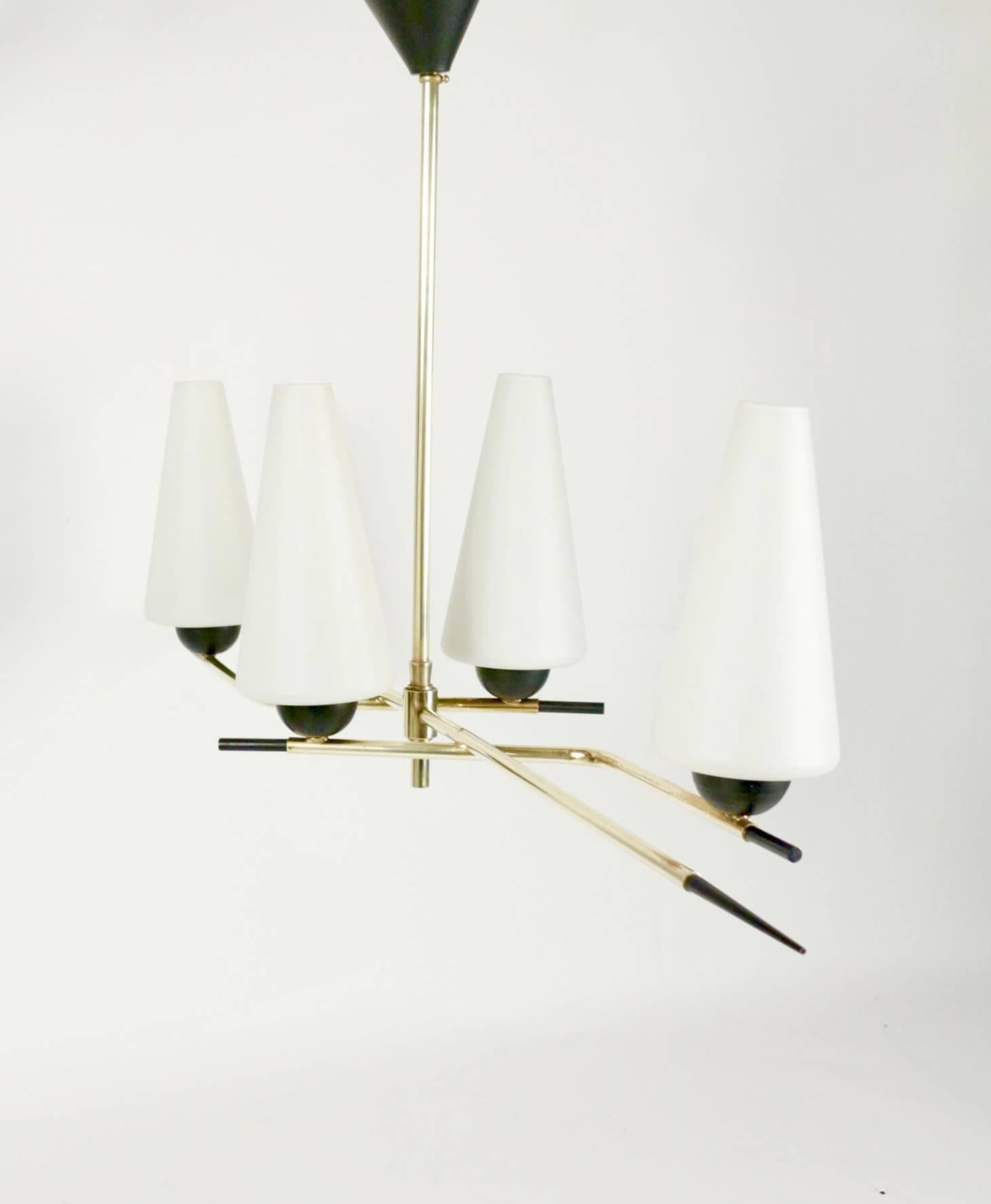 1950s asymmetrical Arlus chandelier.

Composed by four brass stems which support four conical white satine glass lampshades. The brass stems are ended by black lacquered point.

The chandelier is fixed to ceiling by the central stem with black