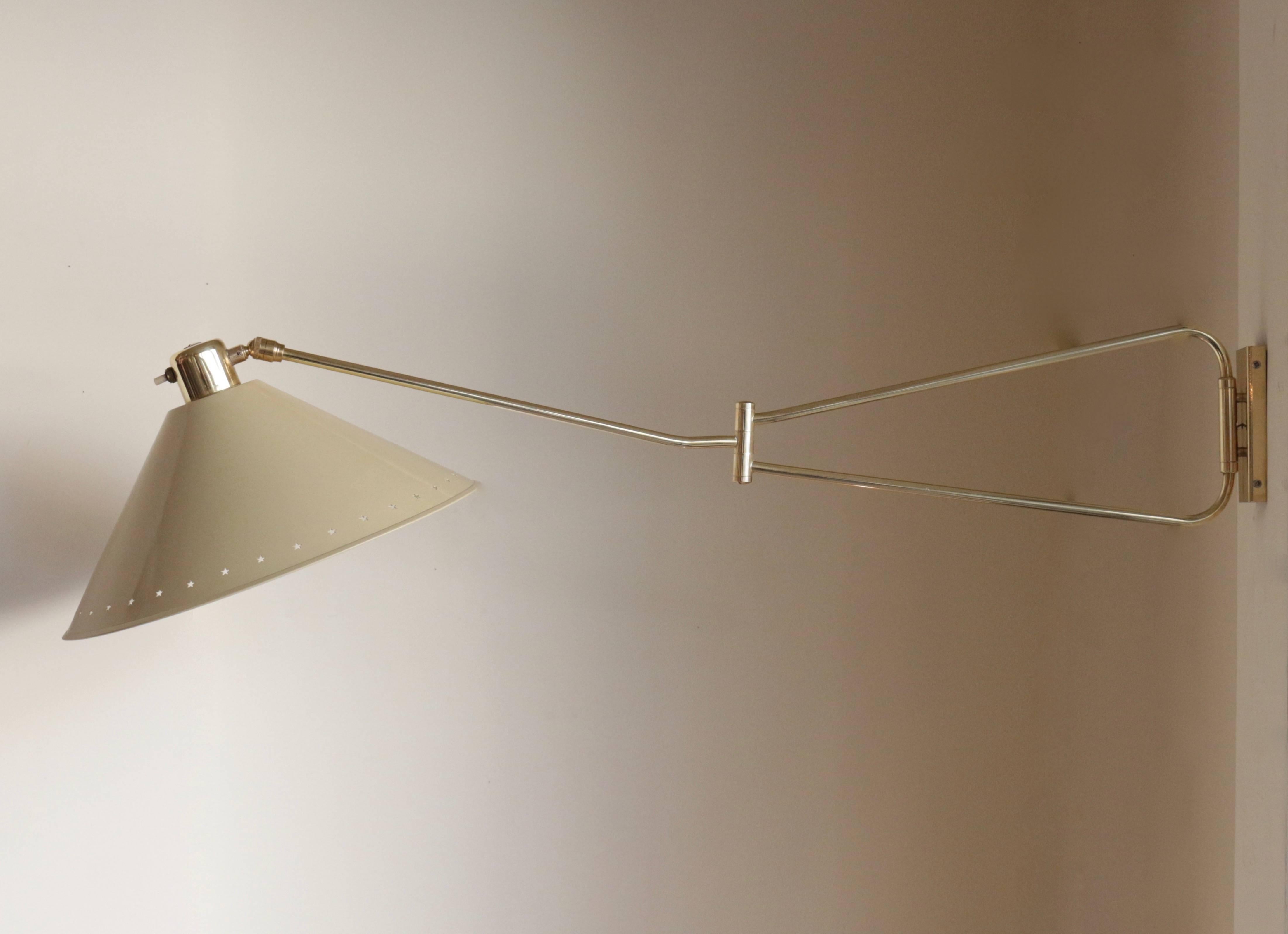 1950s articulated wall light by Lunel.

The long brass arm has two articulations. It could be folded in tow or fully extended. The conical lampshade is off-white lacquered.
The power switch is located on the lampshade top.

One bulb.