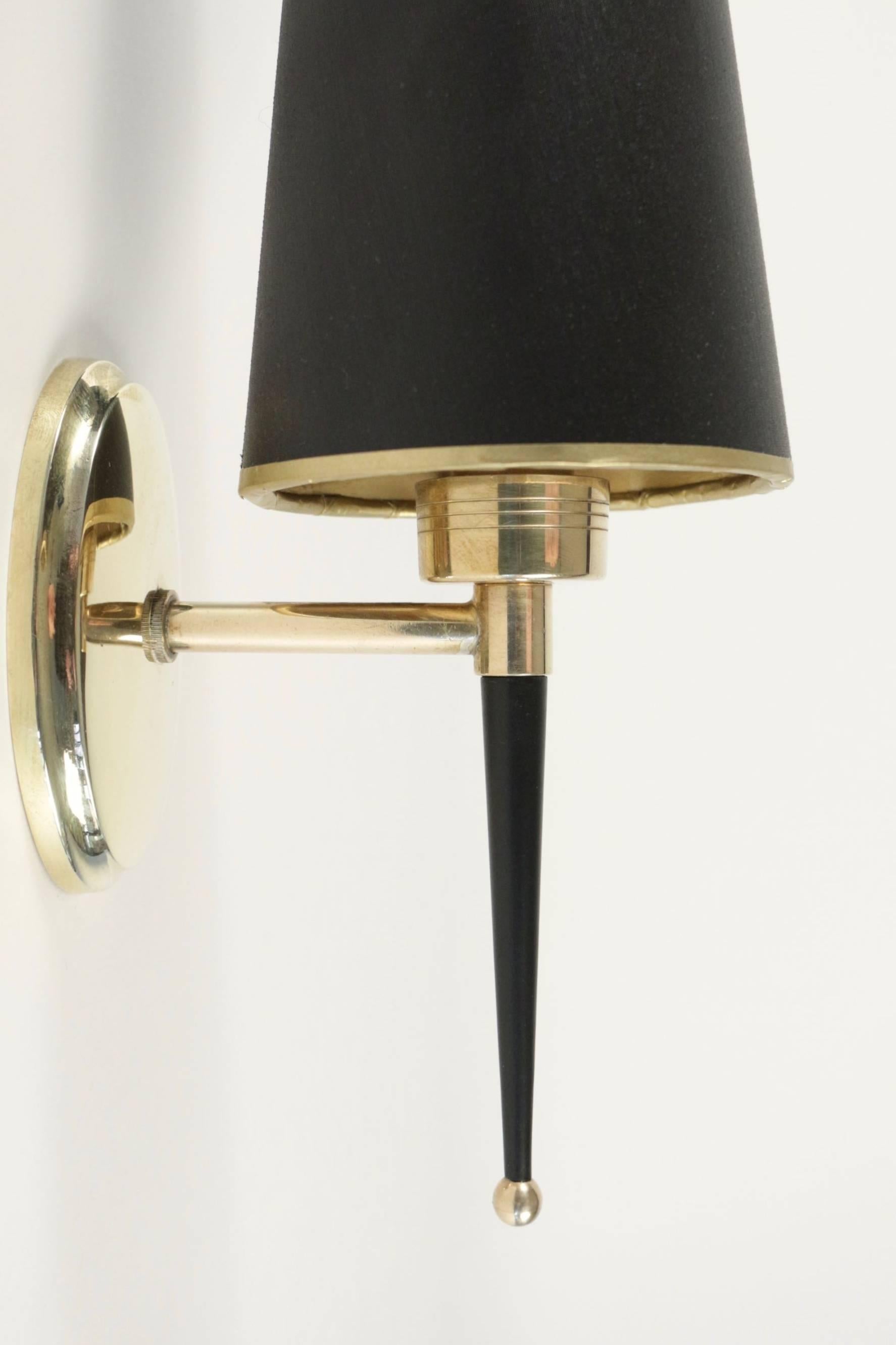 1950 pair of Lunel sconces.

The oval backplate is made of brass and supports one lighted arm with a black lacquered steel ended with a brass ball.
Handmade lampshade made of black cotton with a gold inner face.

One bulb per sconce.
  