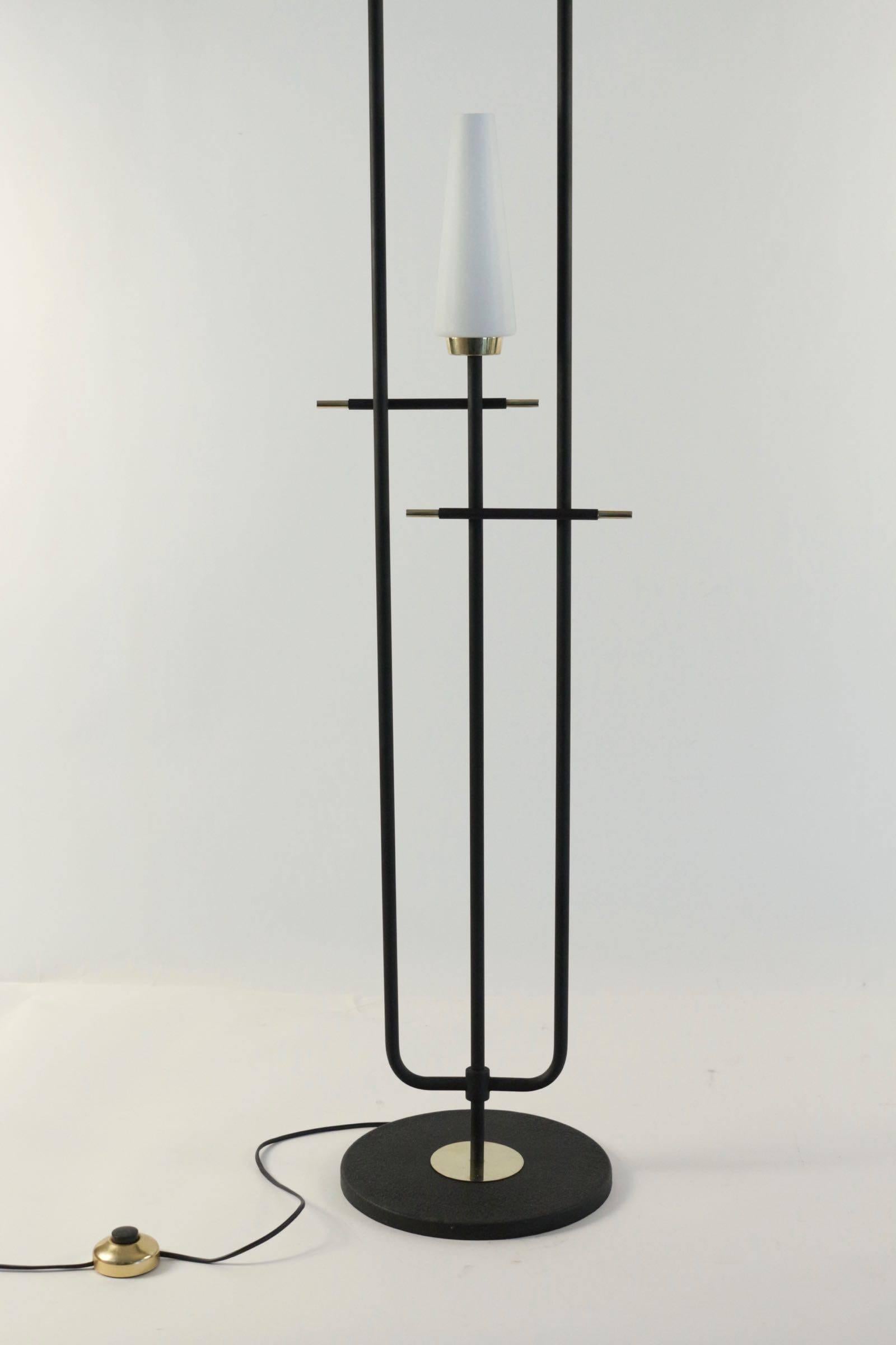 1950s Arlus floor lamp.

Composed by three black lacquered stems ended by three conical white satine glass lampshades, highlighted with brass pieces.
Three bulbs.
  