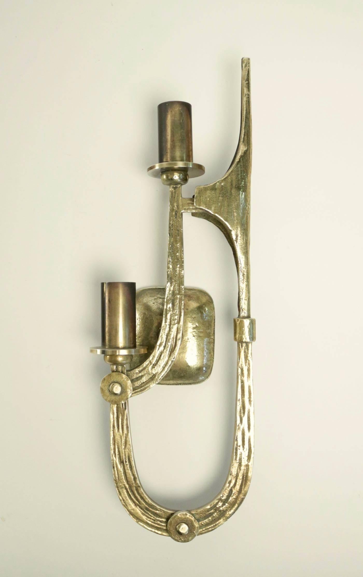 1970s pair of Brutalist bronze sconces   Angelo Brotto.

Each sconce consists of two lighted arms made of solid gilded bronze adorned with a Brutalist motif and gilded bronze nails heads. The highest arm ended in arrow shape. Hollow bronze back