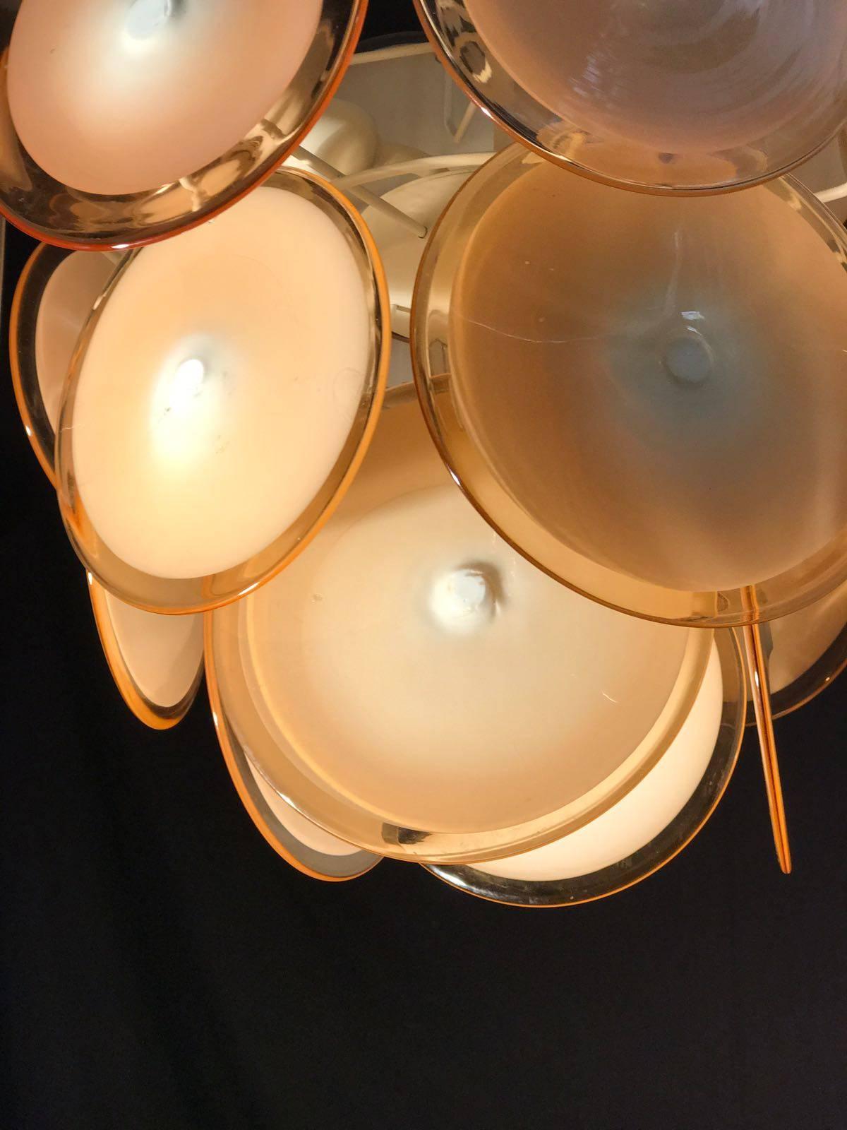 Chaque lustre est formé de 24 disques de miel en verre précieux de Murano, disposés sur plusieurs niveaux. Neuf lumières. Mesures : Hauteur sans chaîne 50 cm.
Disponible également avec des disques blancs.