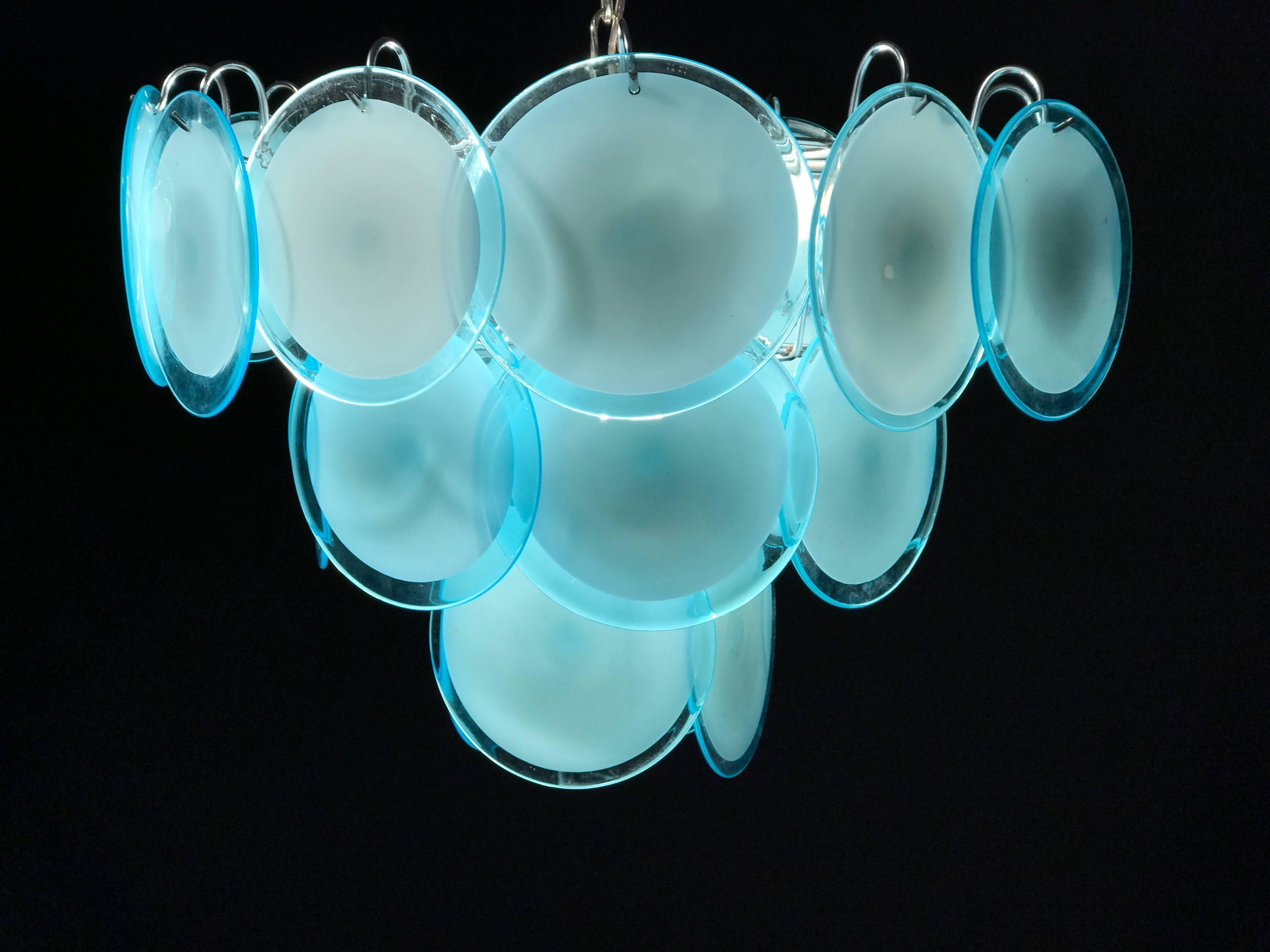 Die seltenen 24 türkisfarbenen Scheiben aus kostbarem Murano-Glas sind auf mehreren Ebenen angeordnet.
Neun E14-Glühbirnen.
Maße: Höhe ohne Kette 40 cm.