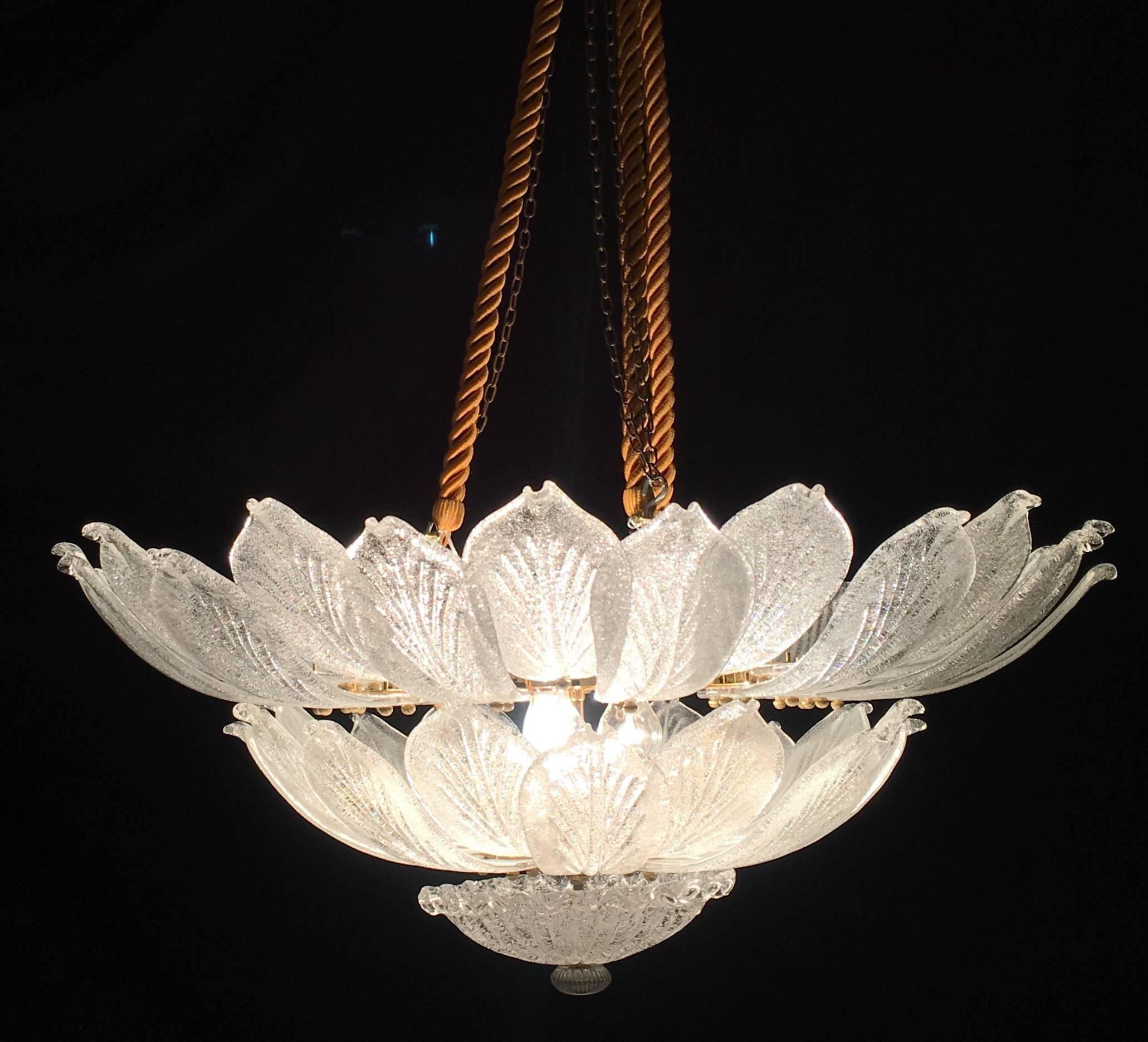 Realizzato in puro vetro di Murano è composto da un numero incredibile di foglie. La struttura è in metallo dorato. 18 luci diffondono una luce magica.
Disponibili 3 di questo articolo.
 Misure: Diametro 100 cm, altezza 46 cm senza catena.
