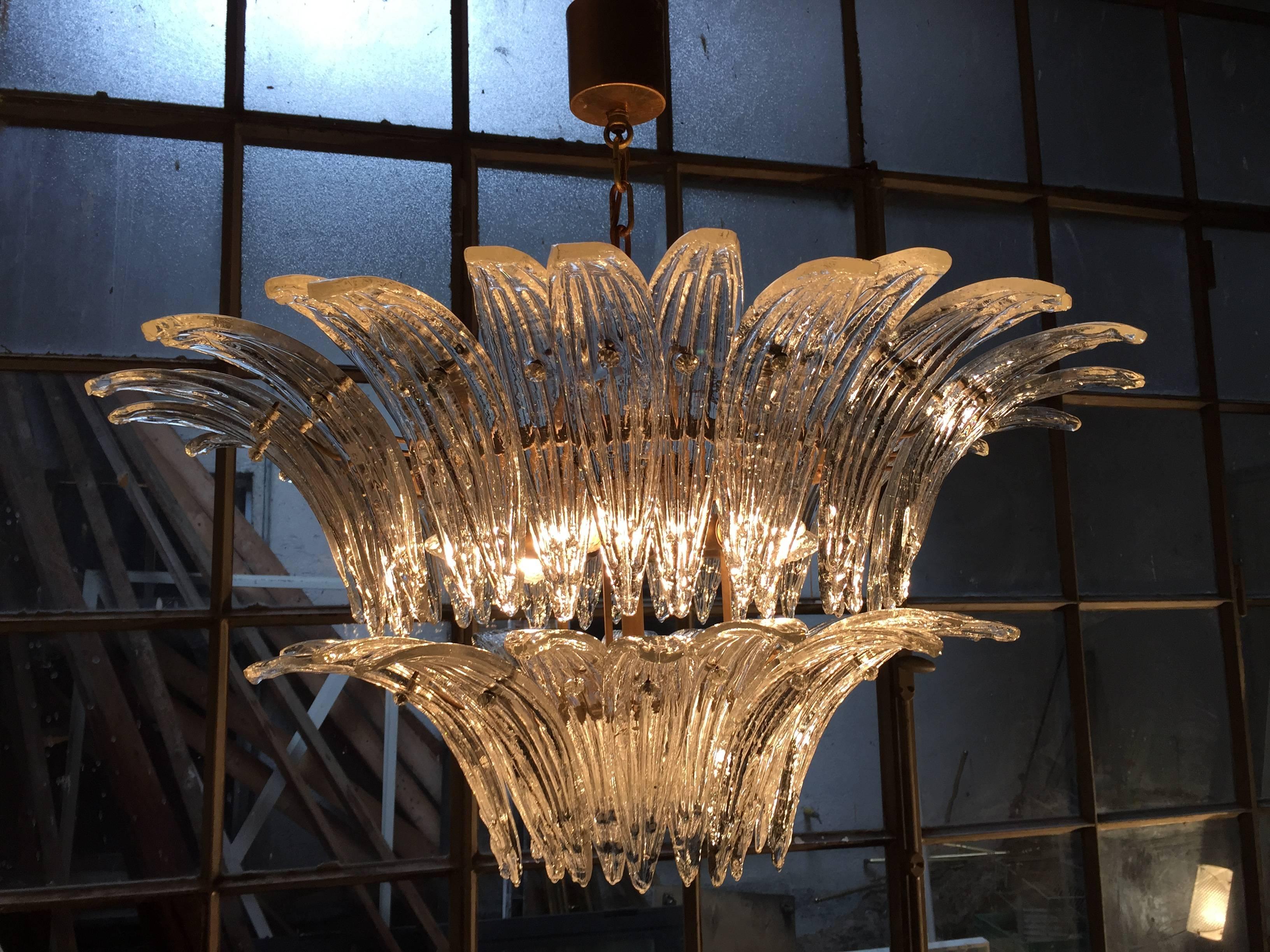The chandeliers were located in the hall of a big hotel on the Amalfi Coast .  Each individual is composed by 58 large leaves in pure Murano glass . Availables 4 pairs of chandeliers and 12 pairs of sconces.