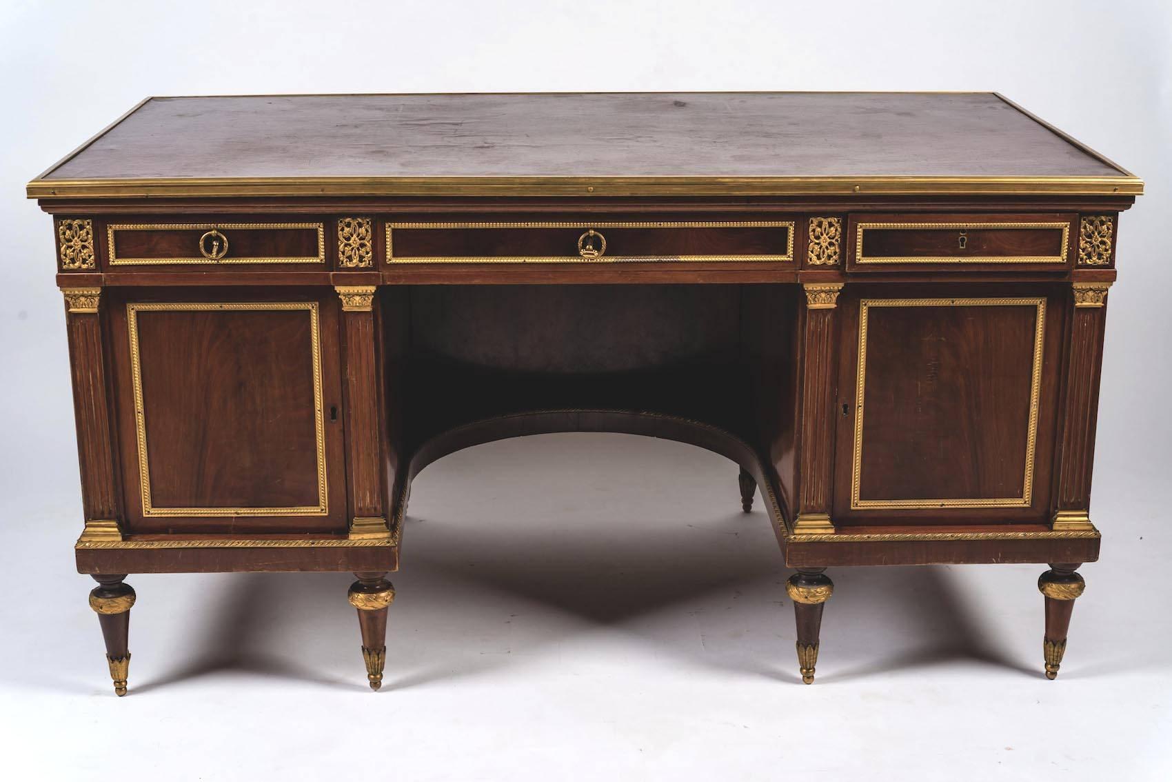 A fine French 18th century mahogany pedestal desk mounts with gilded bronze. Both sides of the desk have small brass knobs that allow wings to be pulled out to extend the writing surface.
Measures: cm 79 x 151 x 82.