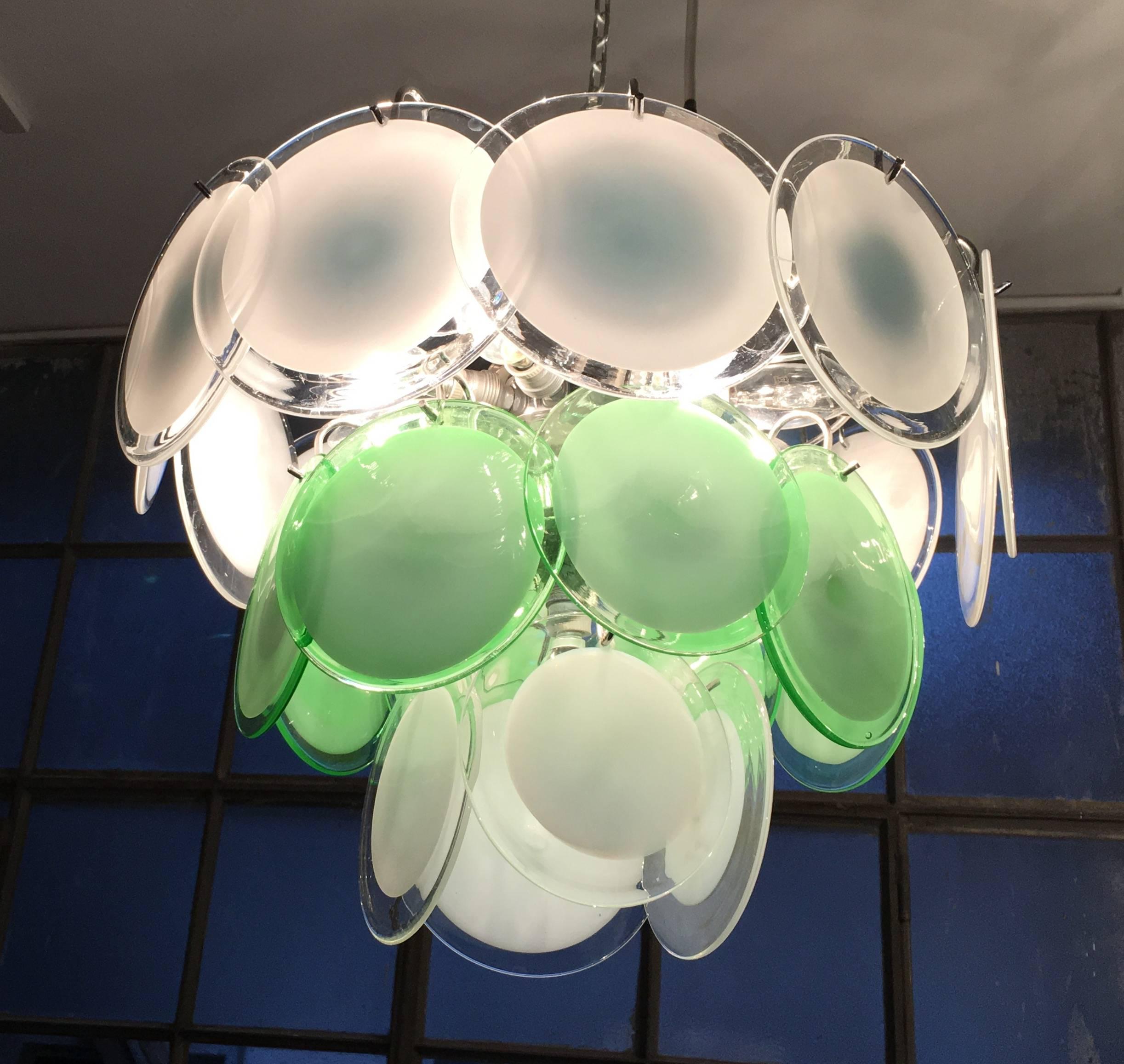 24 white and green discs of precious Murano glass are arranged on three levels.
 