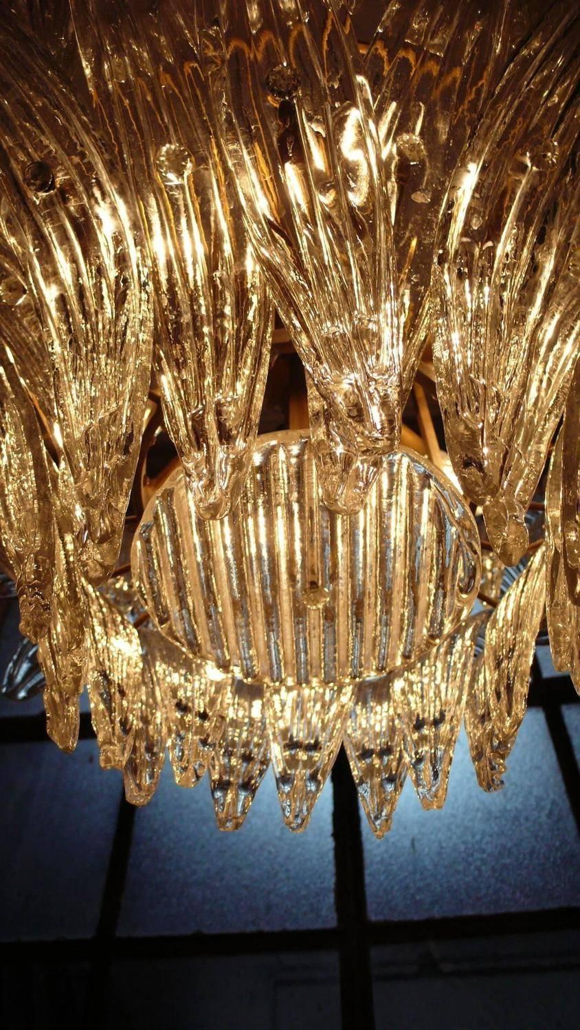 The chandelier were located in the hall of a big hotel on the Amalfi Coast. Each individual is composed by 58 large leaves in pure Murano glass. Available four chandeliers and 12 pairs of sconces.