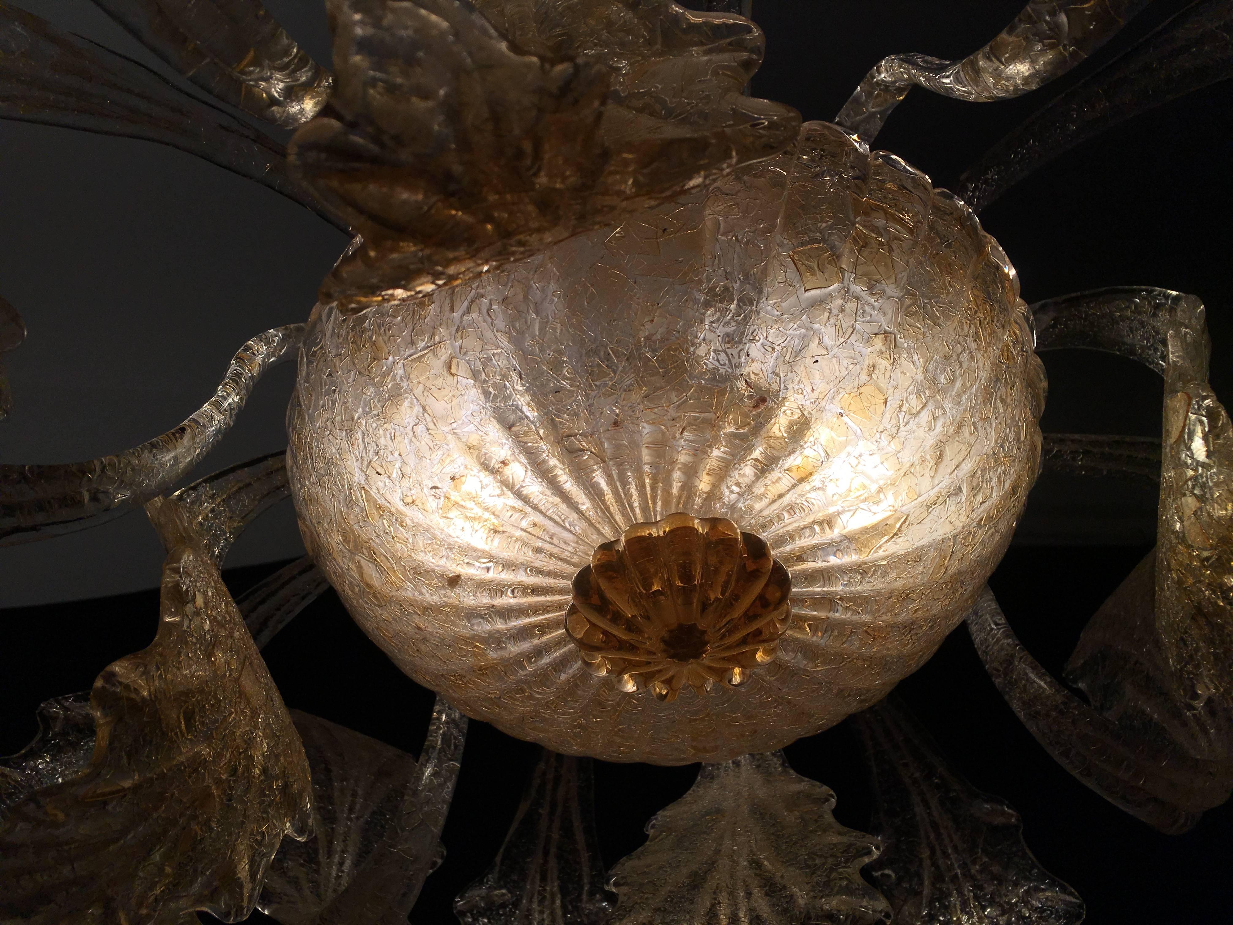 Elegant and charming chandelier with gold inclusions. It consists of 14 leaves in blown Murano glass.
   