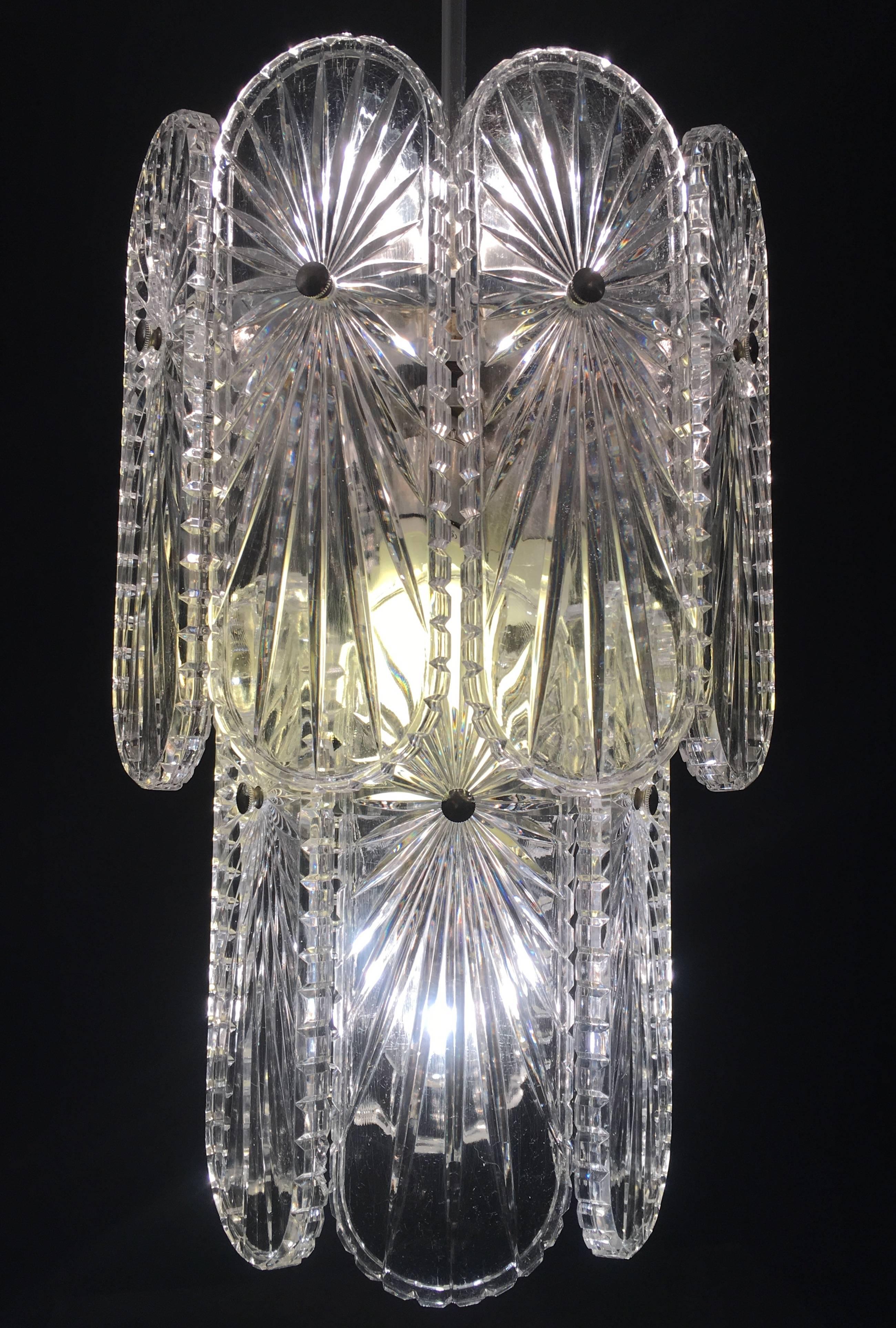 Chandelier with stylized glass elements on a brushed nickel frame.
  
