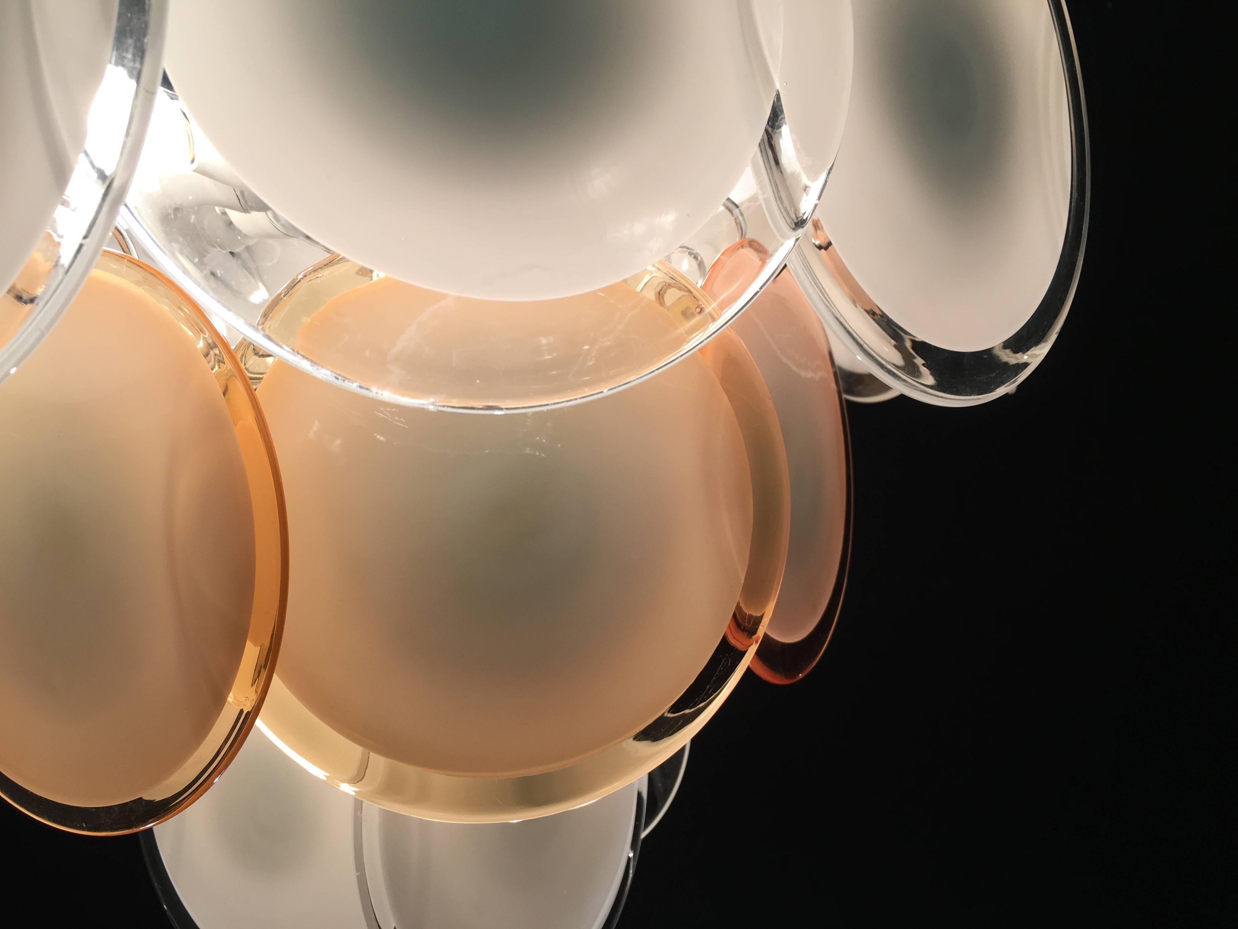 Les 24 disques blancs et miel en verre précieux de Murano sont disposés sur des niveaux de sol. Neuf lumières.
 