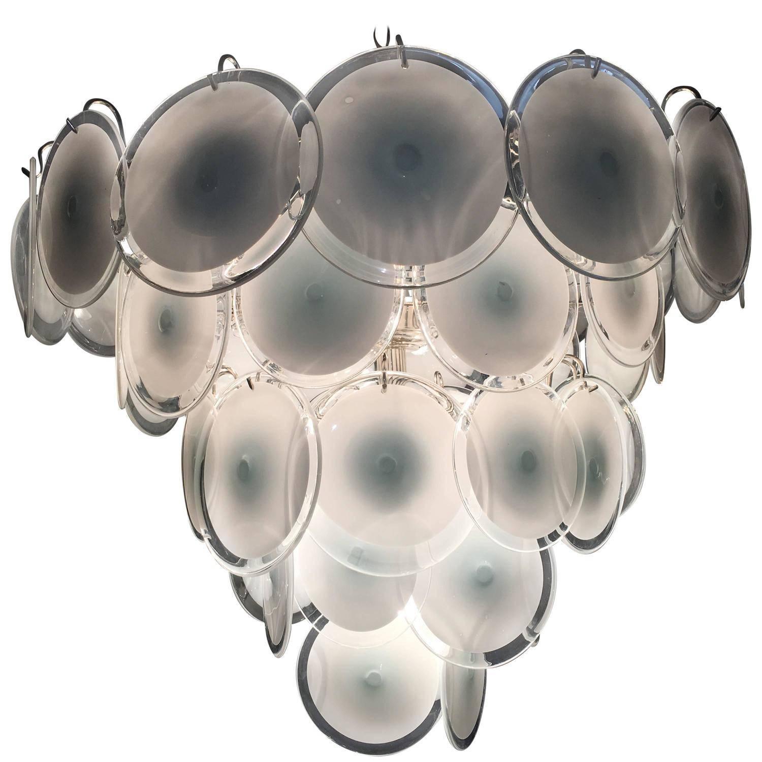 Spectacular chandelier by Vistosi made of 50 Murano discs white put on five floors.
Available also a pair and a pair od wall scones on request.
Nine E14 light bulbs. 