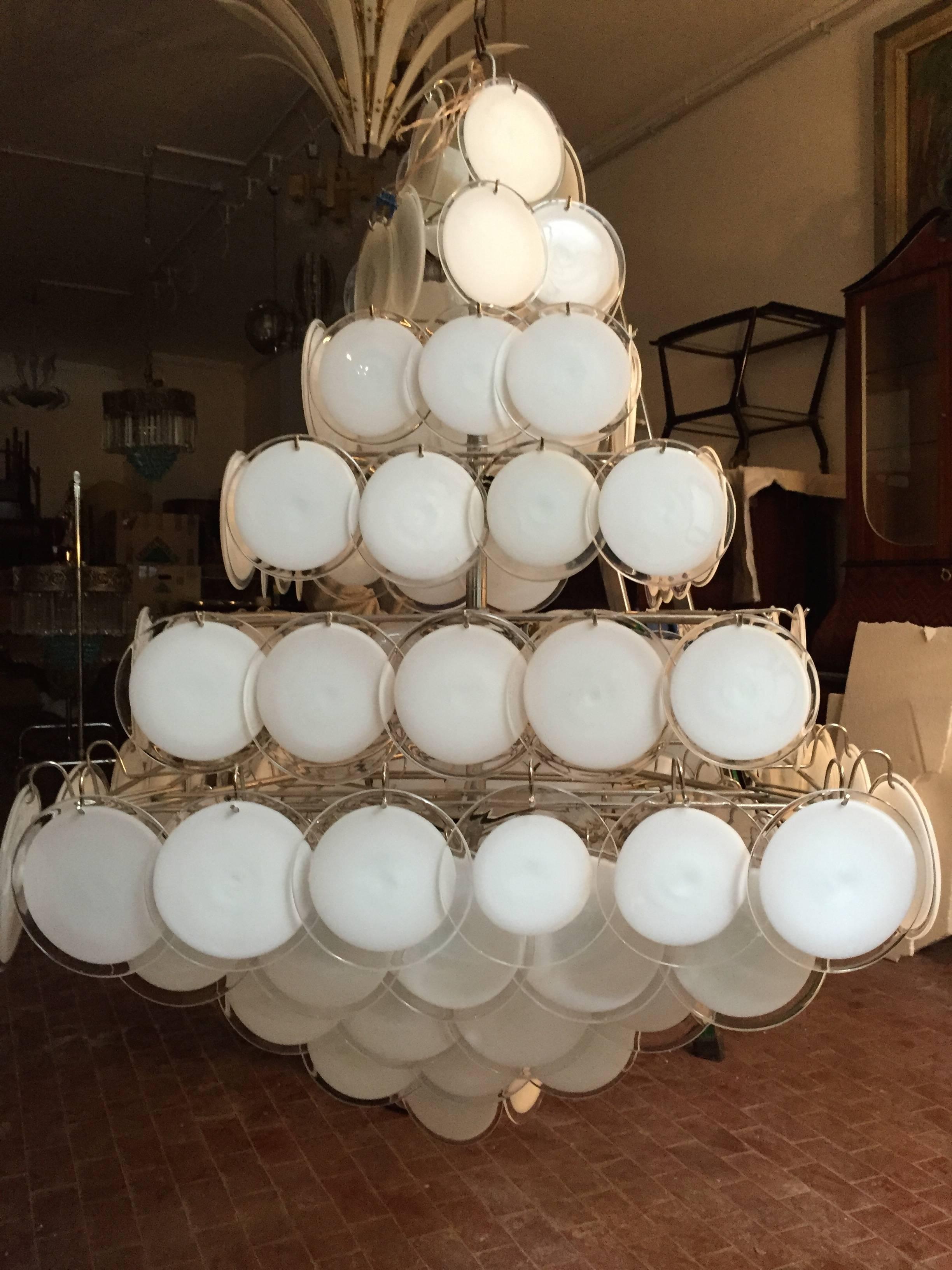 A chandelier of rare beauty and elegance. 136 Murano glass discs, disposed in ten rows, forming two overlapping pyramids. A pair is available.