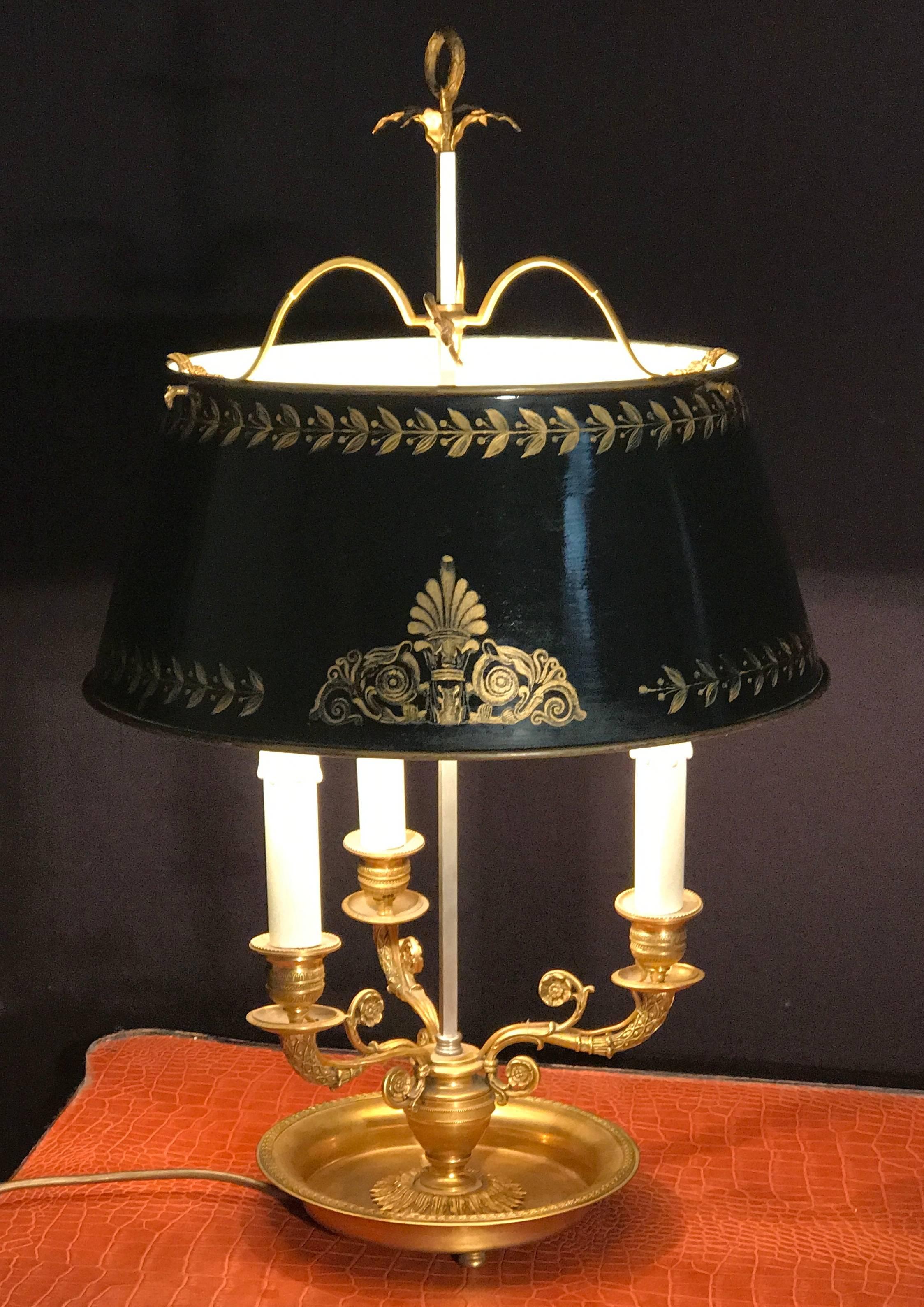 Elegant Empire style gilded bronze bouillotte lamp with black tole painted adjustable shade, decorated with gold-colored patterns.
We can deliver wired for US standard.

             