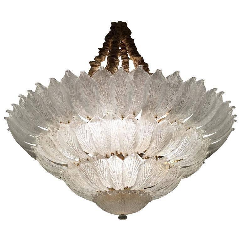 Realized in pure Murano glass, each chandelier consists of an incredible number of leaves. The structure is plated with gold. 18 lights spread a magical light. Measures: diameter 156 cm, height 58 cm + chain. Also available are three ceiling lights