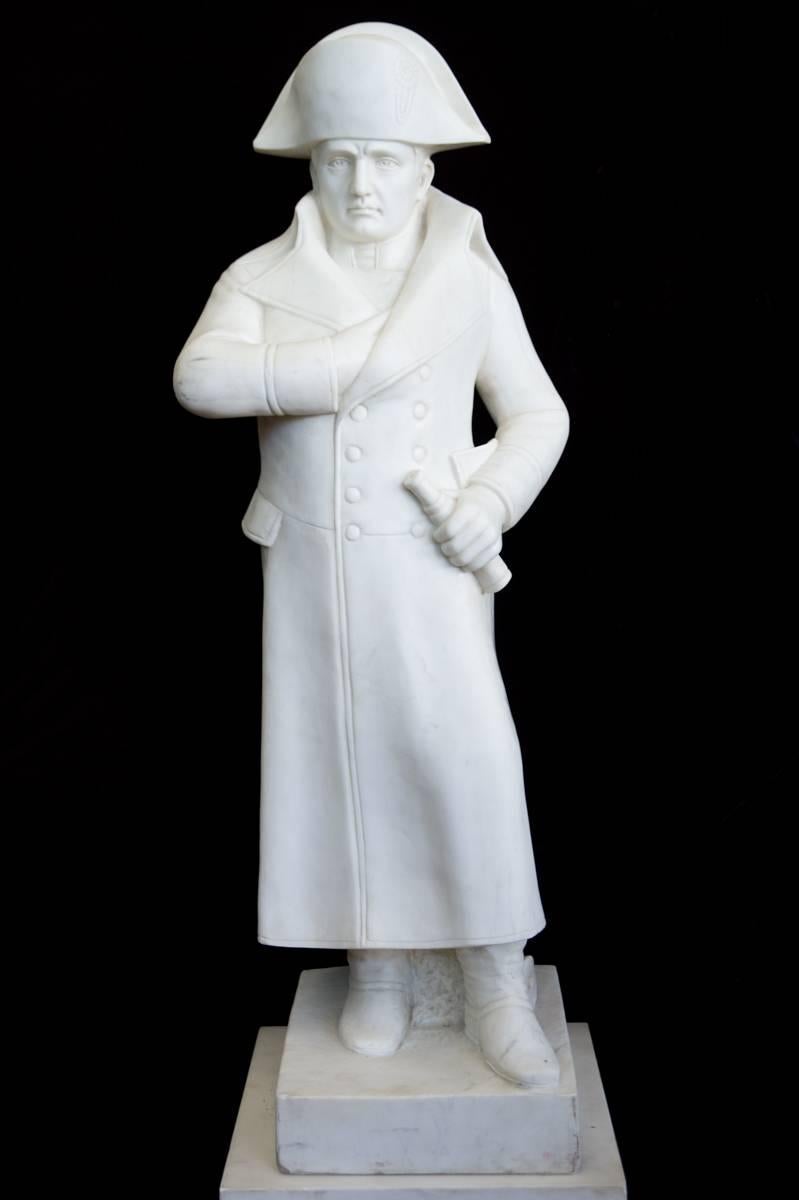 A white carved marble figure of Napoleon Bonaparte standing with one hand in his jacket, raised on a gilt bronze mounted white marble pedestal.

Overall height: 75
