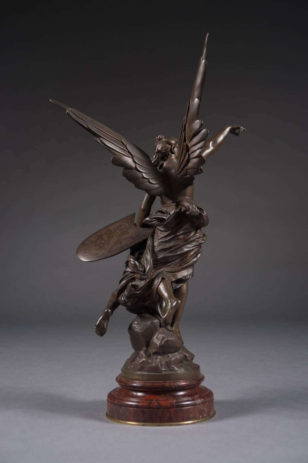 A very fine French antique patinated bronze figural group titled Pro Patria by Edouard Drouot 
(French, 1859-1945) late 19th century.

Depicting a figure of winged Victory with a soldier in attendance holding a sword and shield, on circular rouge