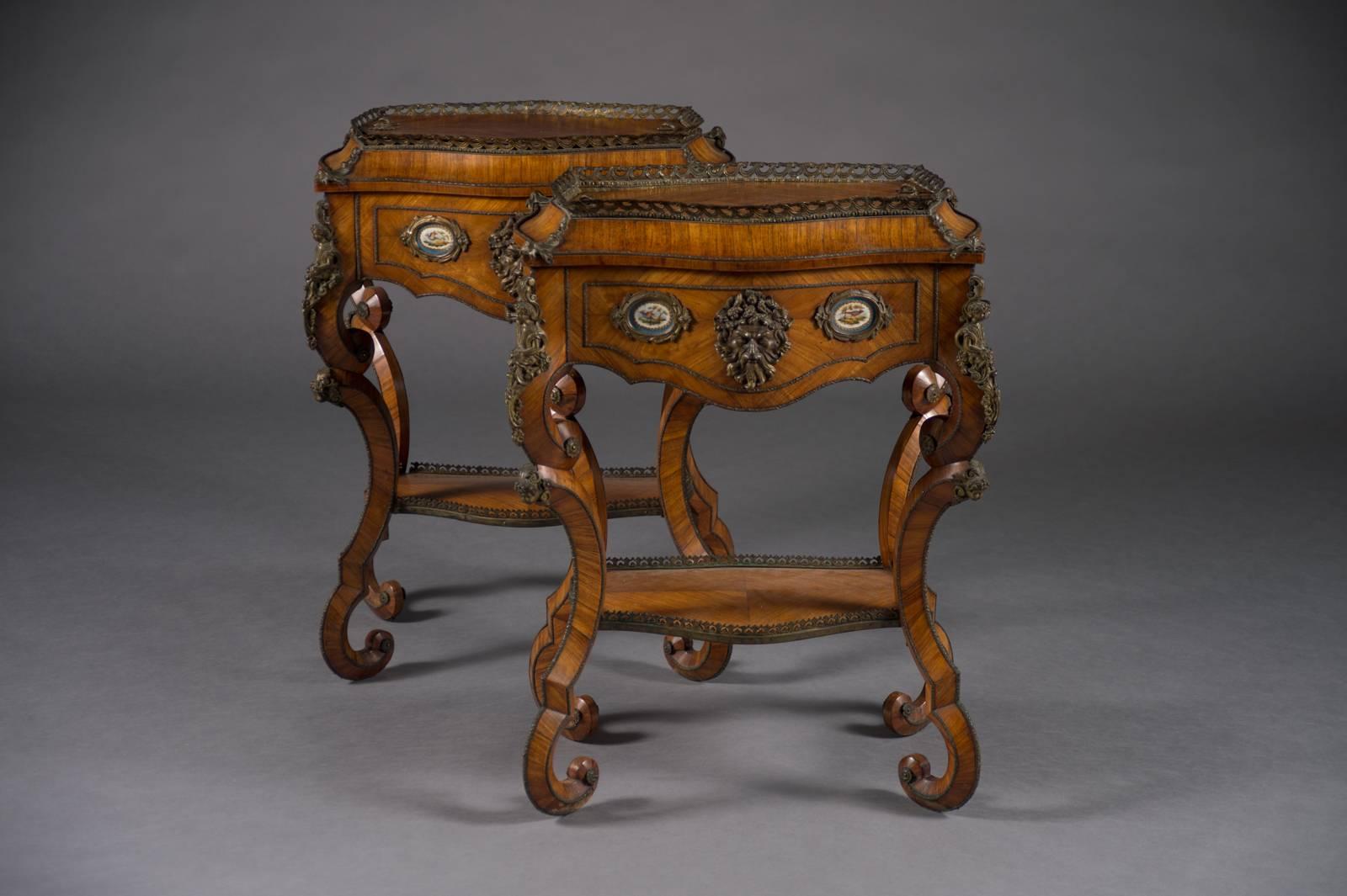 A fine pair of French Rococo style bonze and porcelain mounted side tables/planters.

The tables have lids which can be taken off and be used as planters.
They are both bronze-mounted with a mythological mask alongside a pair of porcelain
