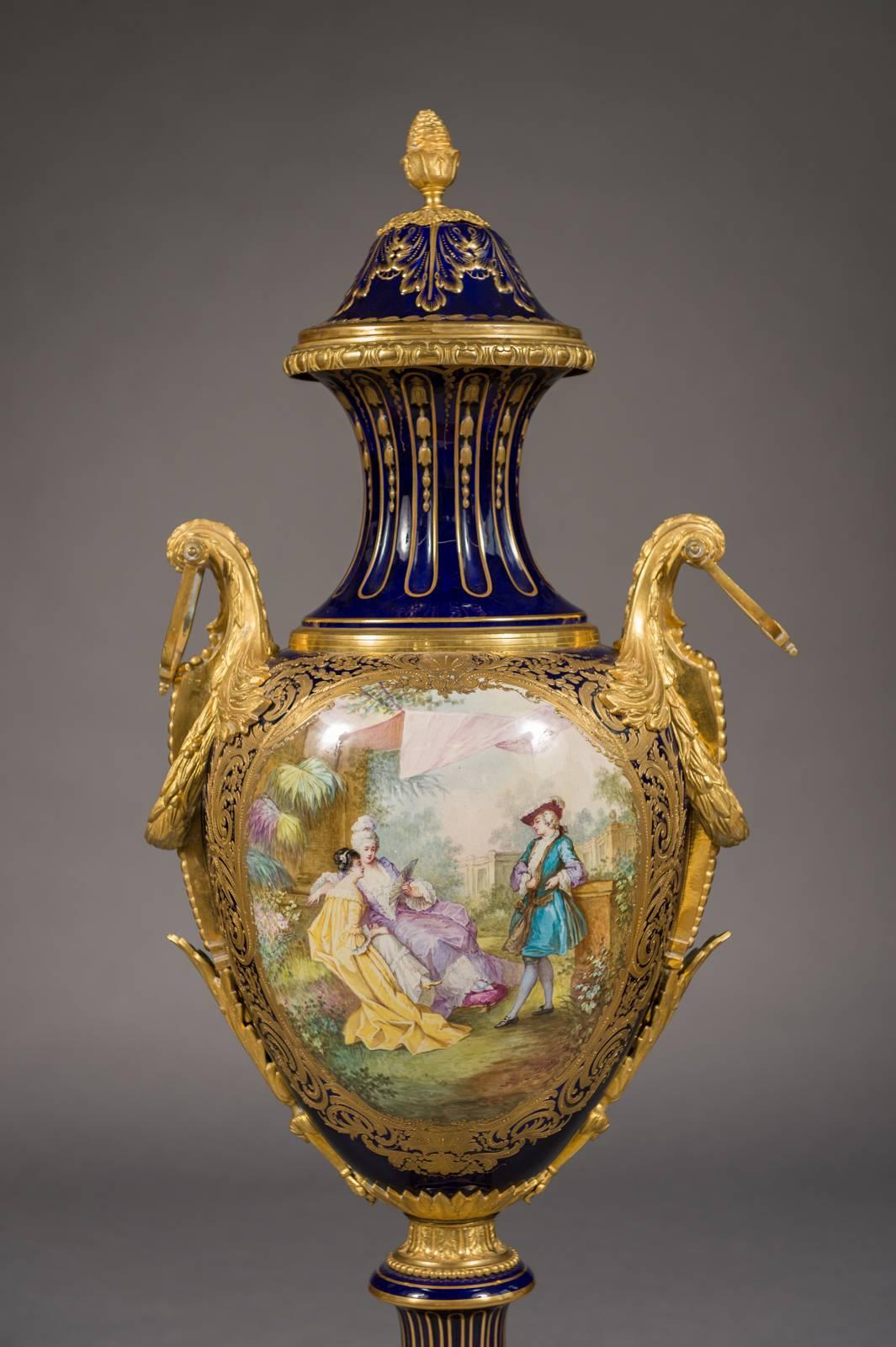 A large and impressive 19th century French 'Sevres' ormolu mounted painted porcelain covered urn. Cobalt-blue baluster form with tooled gilt bordering cartouche centered with hand painted romantic scene depicting a standing man and two ladies. The