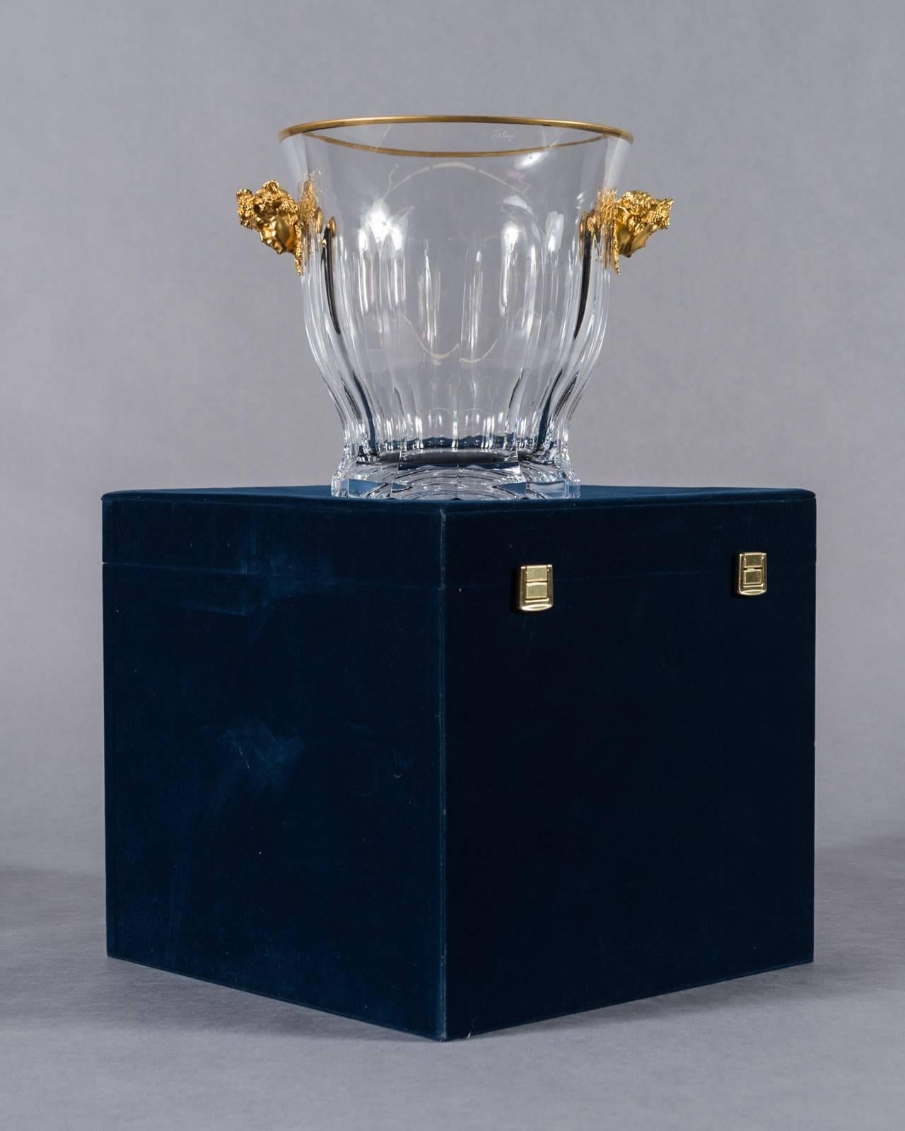 A cut crystal and gilt bronze-mounted Bacchus, Tatianna Faberge Champagne cooler

Having two gilt bronze mounts depicting Dionysus the god of the grape harvest.

Signed on Bottom Tatianna Faberge, comes with original box.

Measures: Height