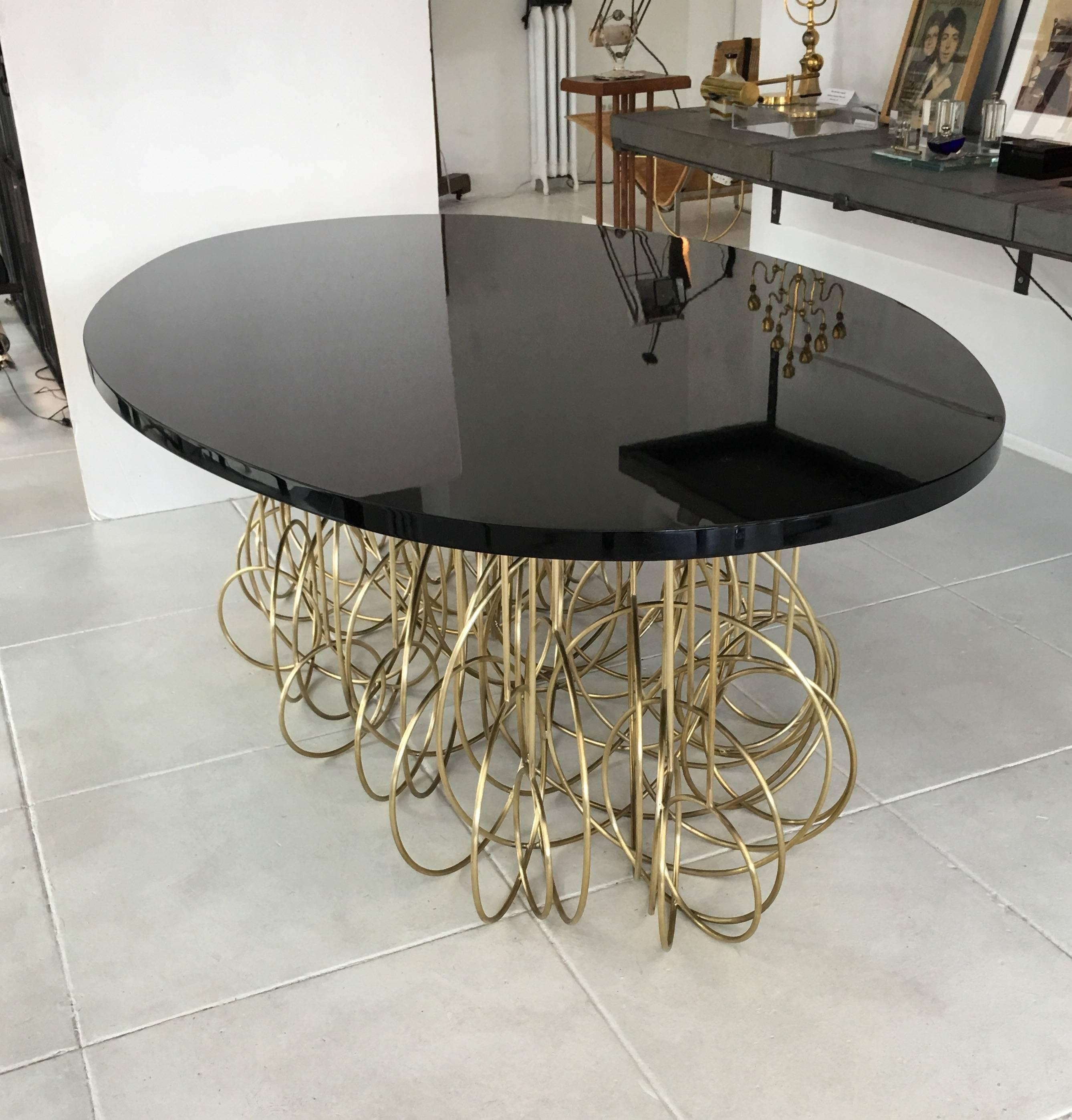 Most unique and extravagant French Dining or Center Oval Table. Combination of brass and 1.5 inch thick black lacquered wood top.