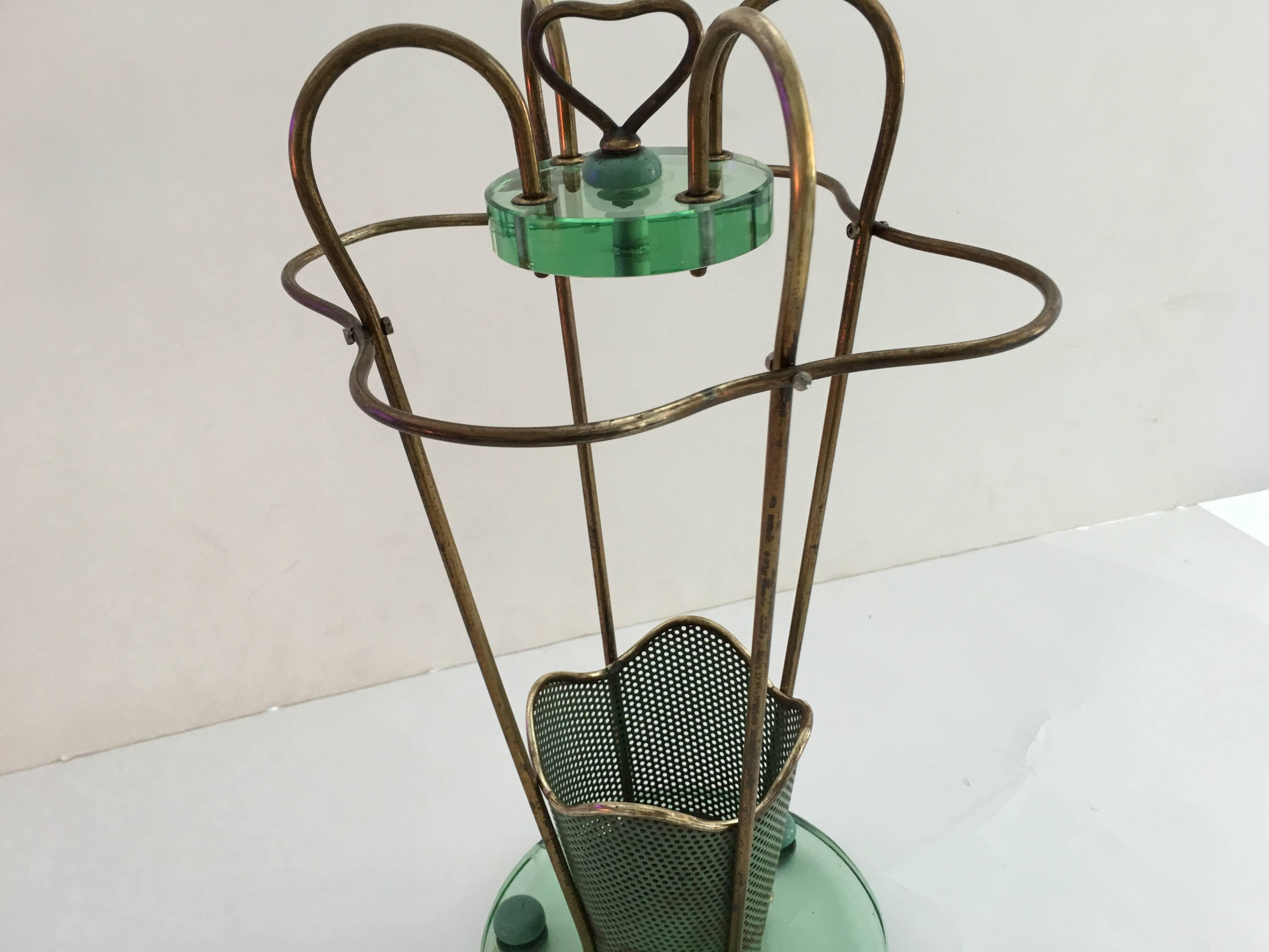 Very rare and exquisite umbrella stand, 1950s. Metal and brass, the base is 1 inch thick glass and 10 inch diameter. Width at the top is 11 inches. Total height is 22 inches.