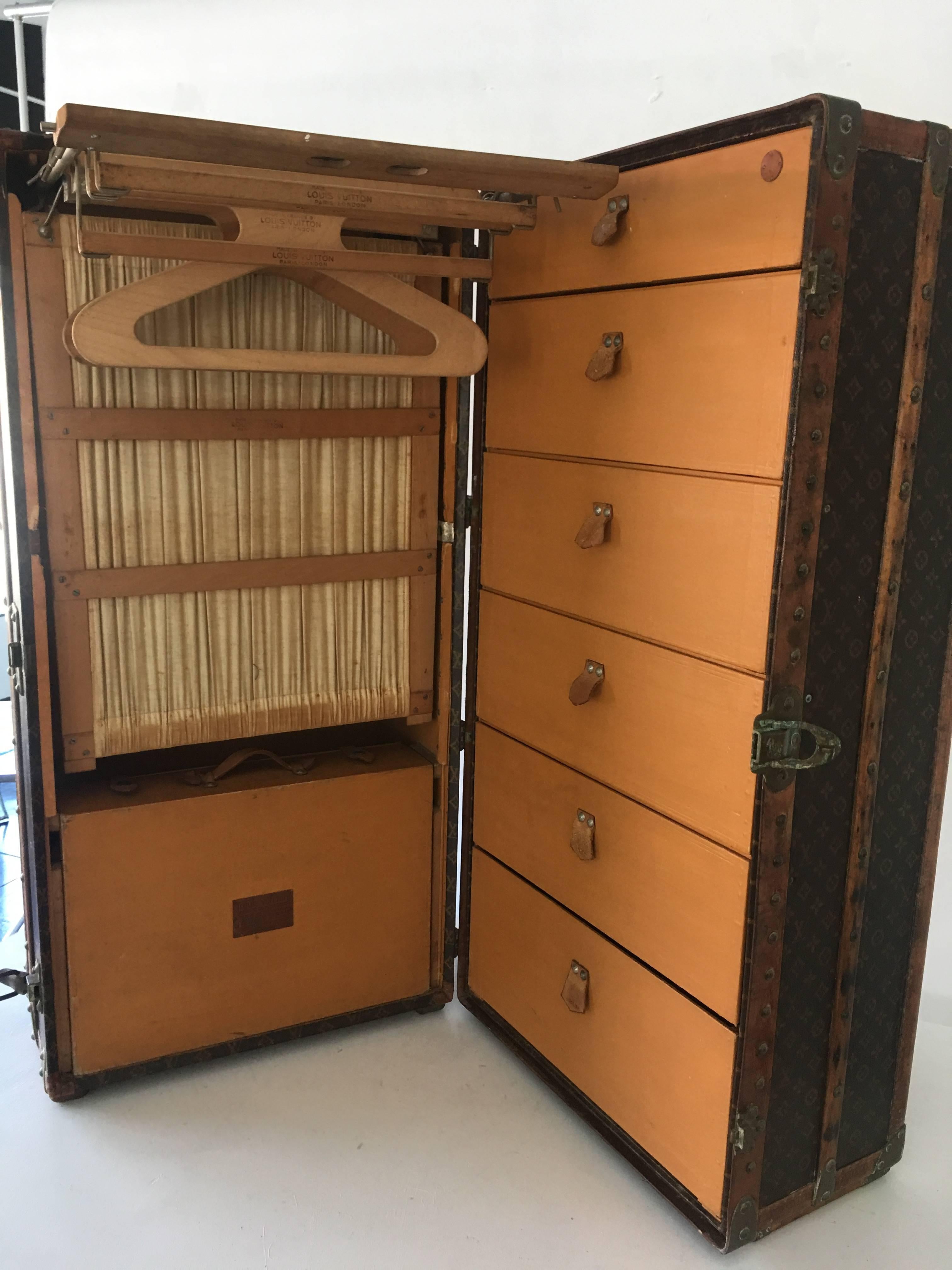 Rare Louis Vuitton wardrobe trunk with all original hardware, monogrammed coat hangers, and leather handle.