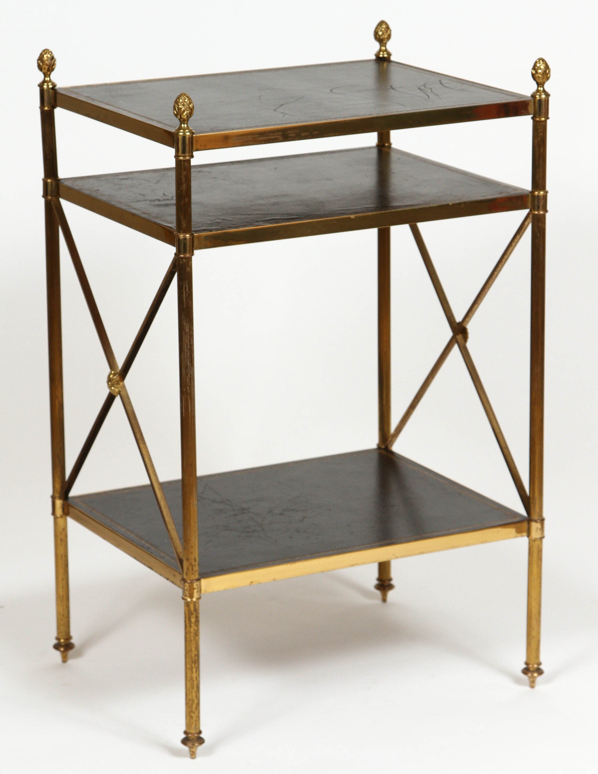 Pair of vintage bronze and brass Maison Baguès side tables. Tables feature three leather topped tiers with hand-tooled Greek key motif in gold and pinecone finials. Made in France, circa 1970. The tables are in good vintage conditions with some