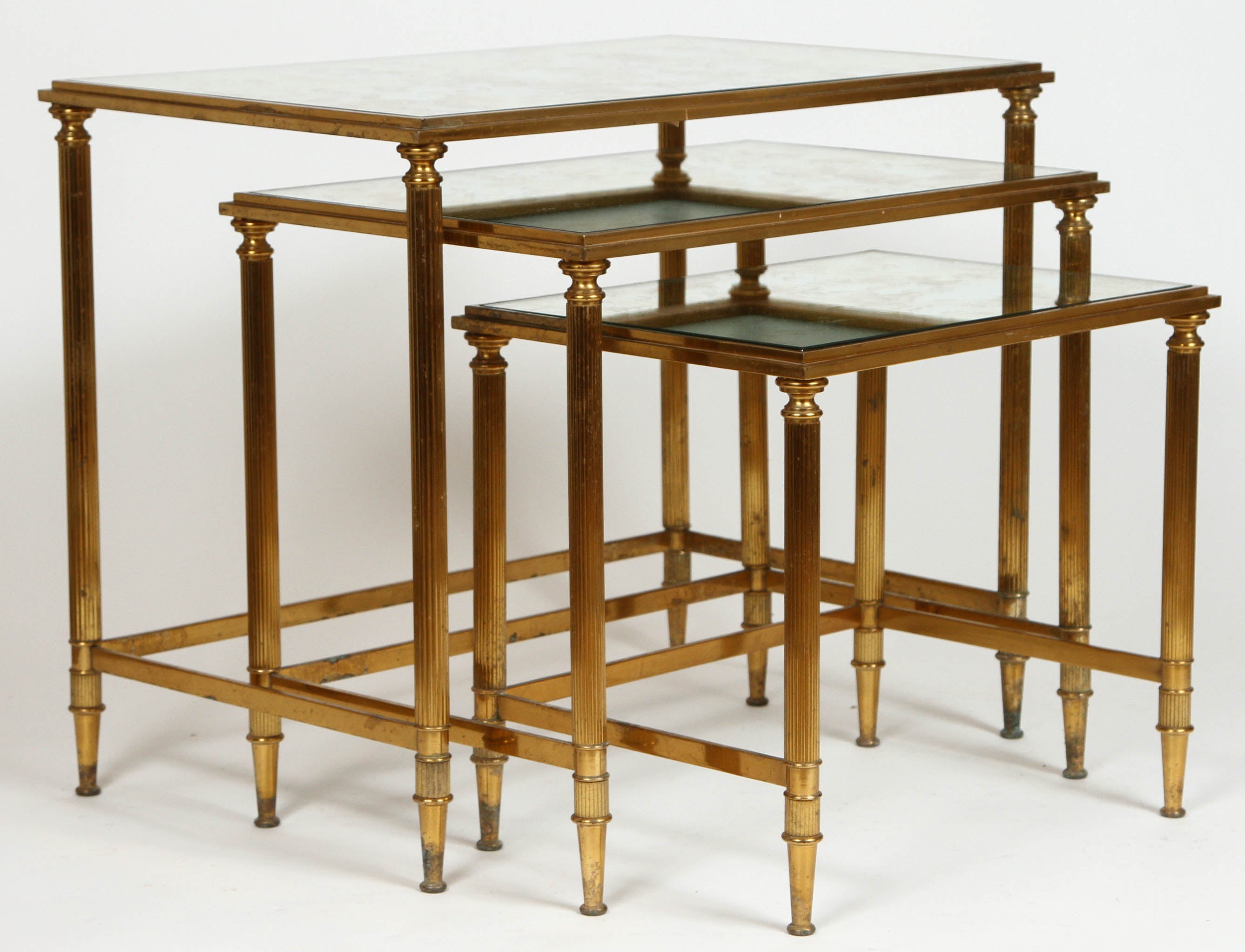 Vintage Maison Jansen bronze nesting tables with original mirrored tops. Set of three tables feature fluted column legs. Made in France, circa 1950-1970.

Dimensions:
L: 17 3/4