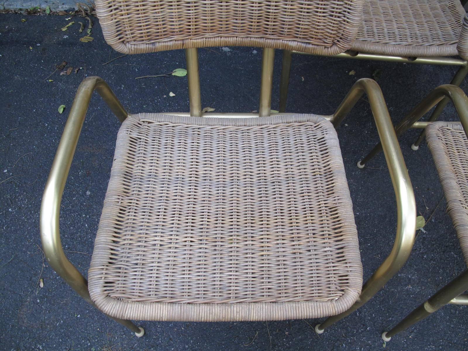 Four woven fiber chairs with tubular frames. Golden brass color on aluminium frames. Labelled on the underside Troy Sunshade. Available as a set of four. Stackable.