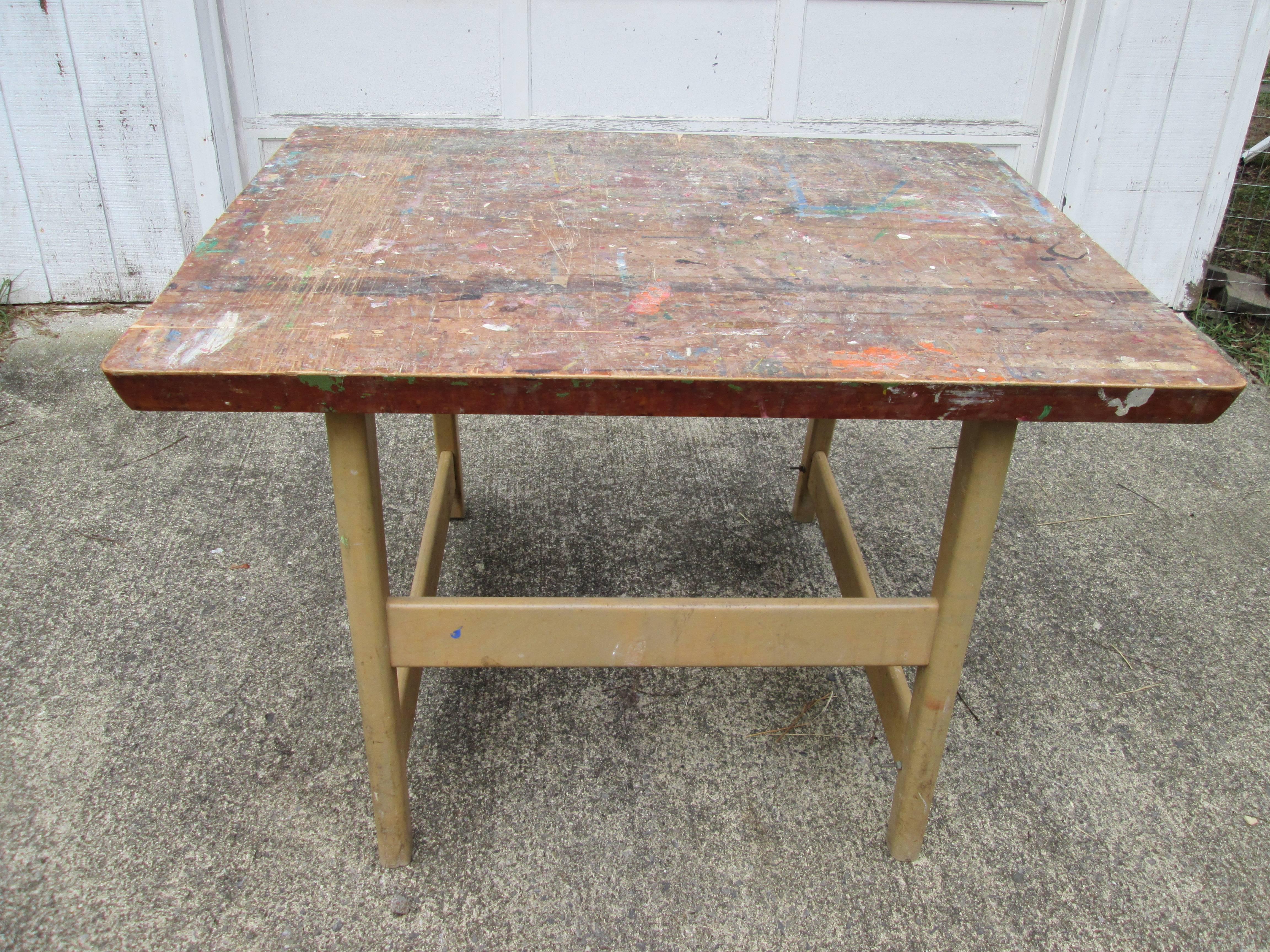 Four similar midcentury tables from an artist studio. Each having a beveled butcher block top and blonde wood legs. 