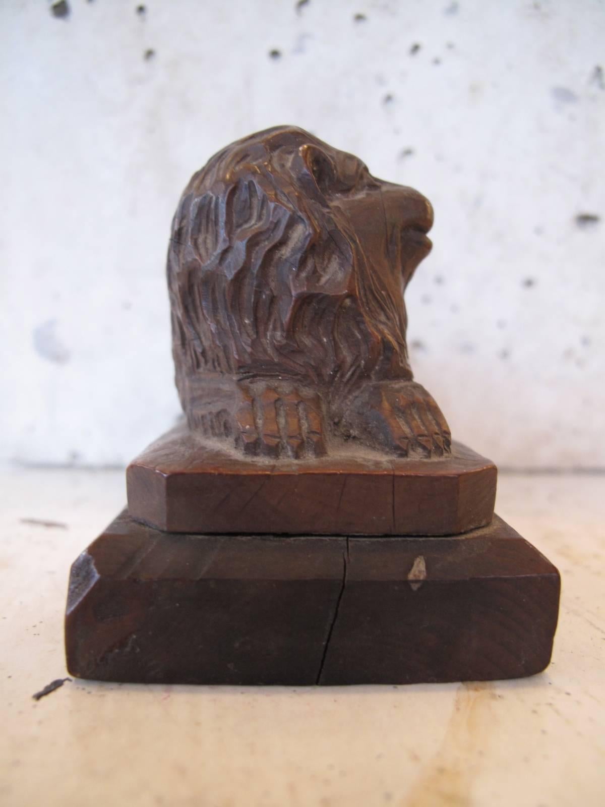 Highly detailed carving of a recumbent lion. Single piece of wood atop a bevelled wood base, mid-late 19th century. Unsigned.