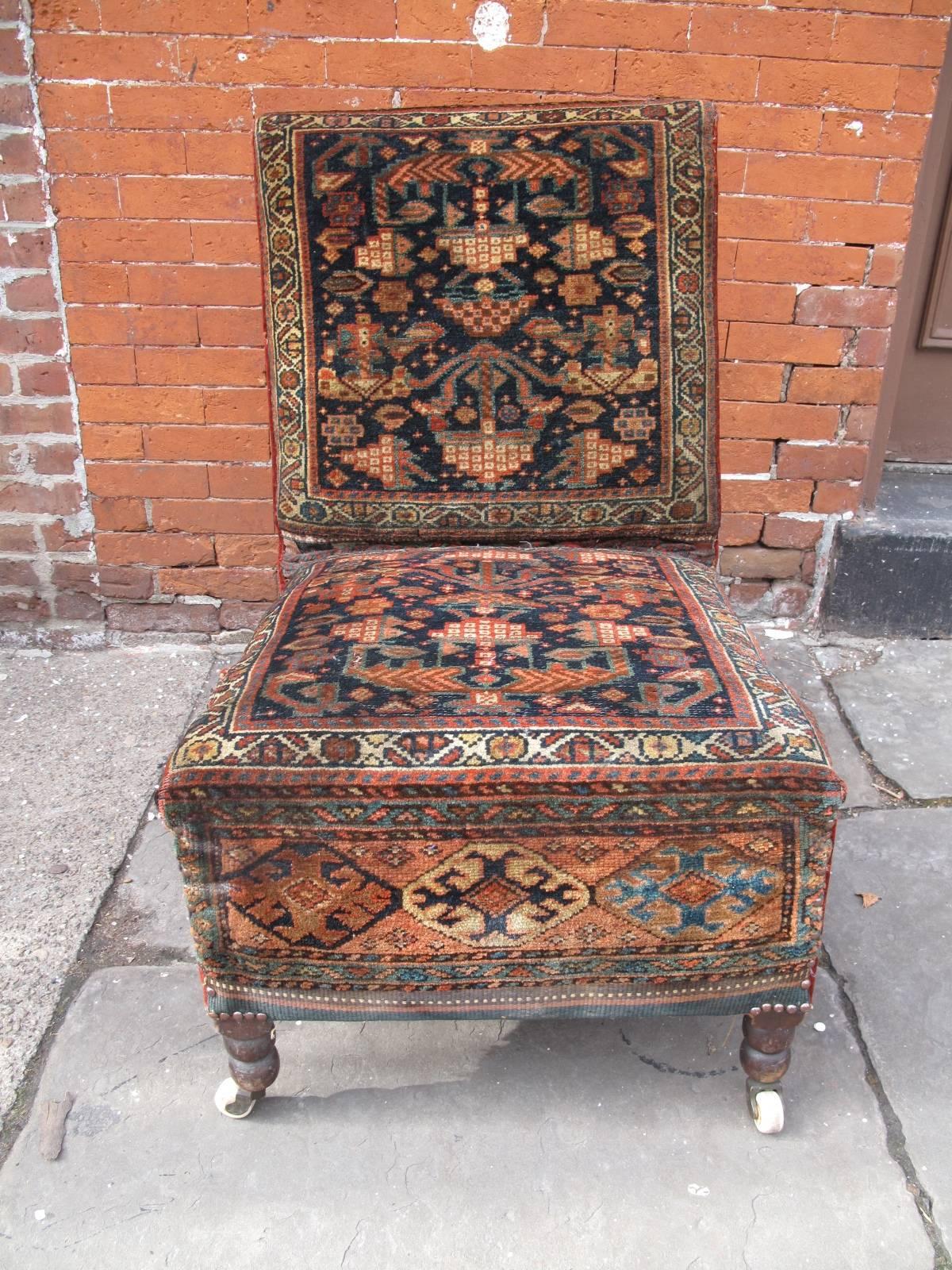 1890s armless chair upholstered in mohair velvet and wool carpet remnants. Ceramic casters on turned legs. Nailhead details.