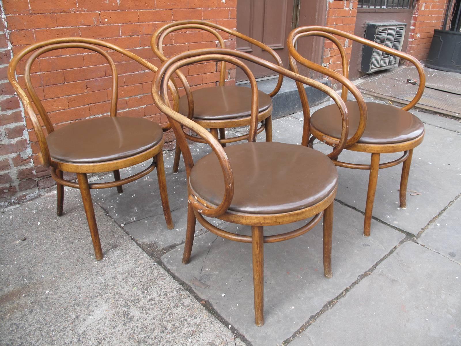 Four Thonet armchairs, no. 209. With replacement seats upholstered in brown faux leather.