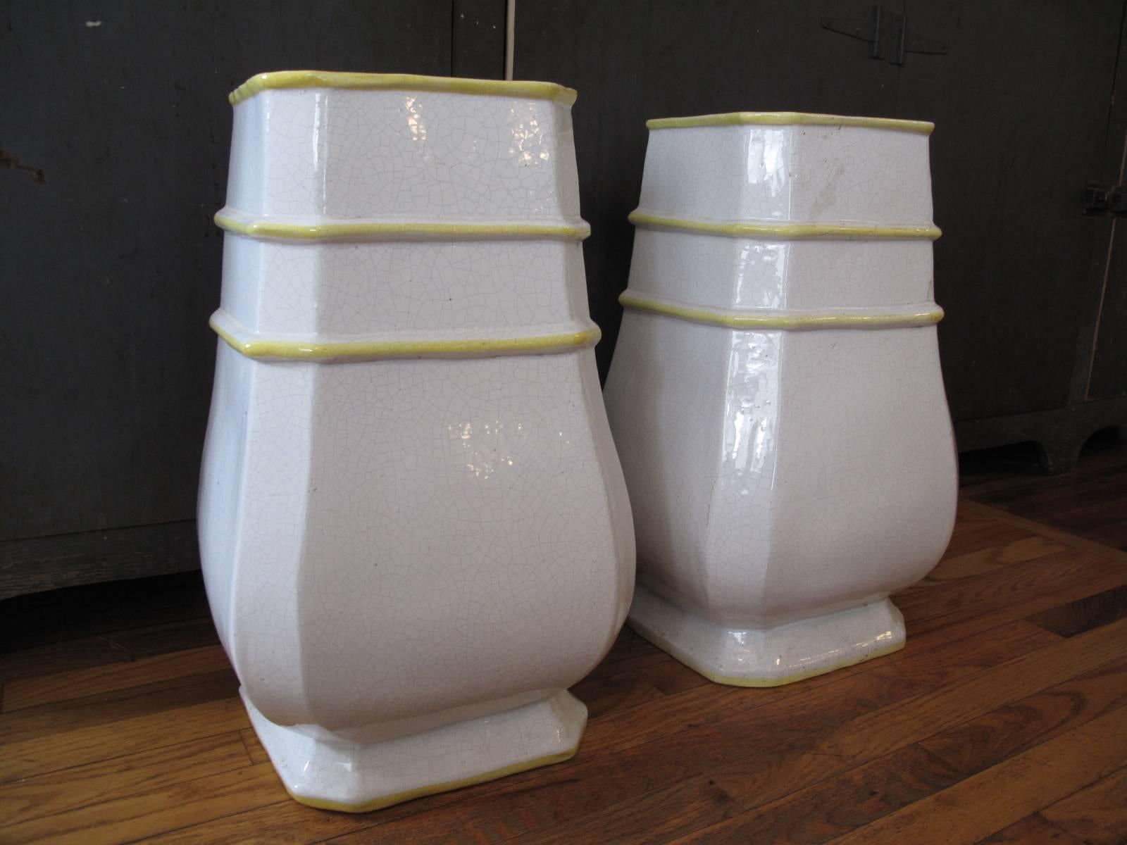 Mid to late 20th century glazed ceramic floor vessels. In ivory crackle glaze. Hand-detailed in yellow along raised details.