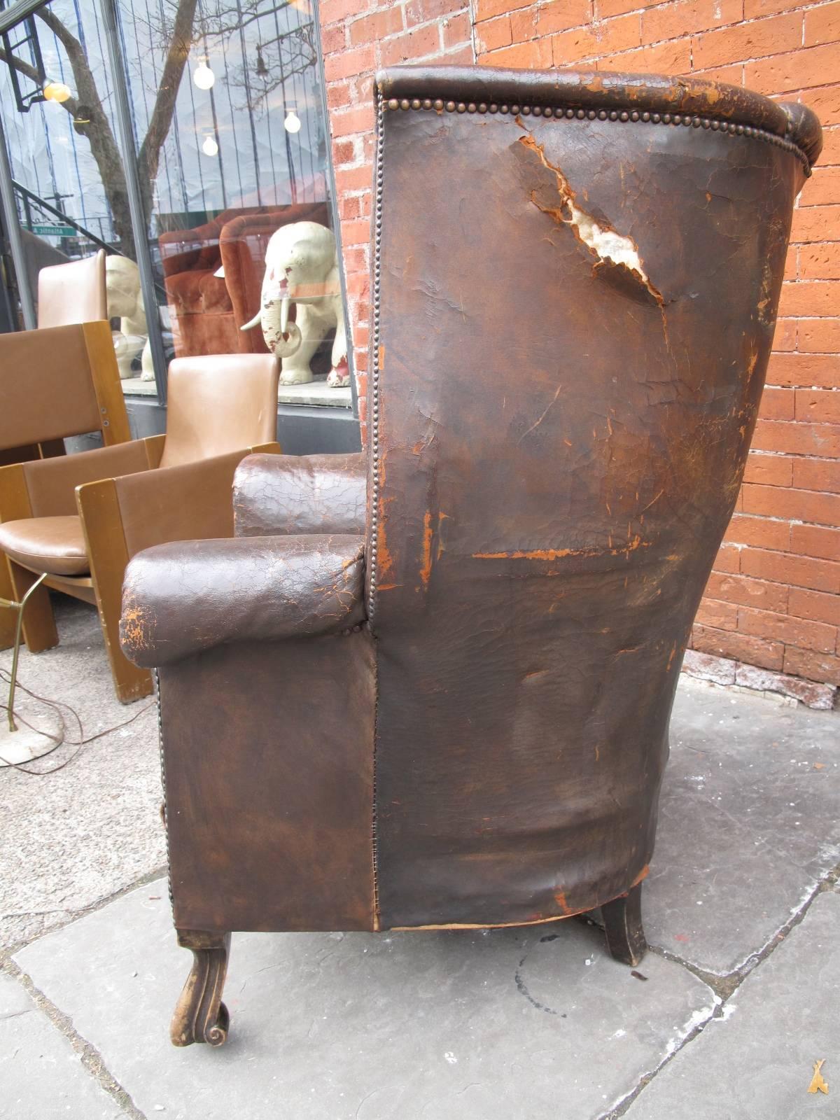 Stately leather armchair with high channelled wingback. Nailhead details throughout. Elegantly carved feet. Single loose cushion with large rear custom snaps. From a Brooklyn, NY collector.