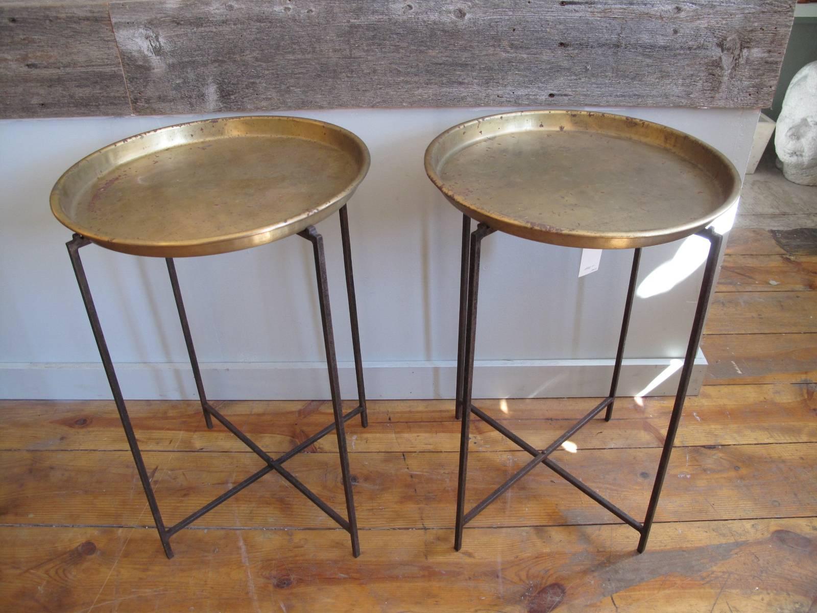 Two 20th century side tables. Minimal iron frame that folds flat. Round spun brass tops.