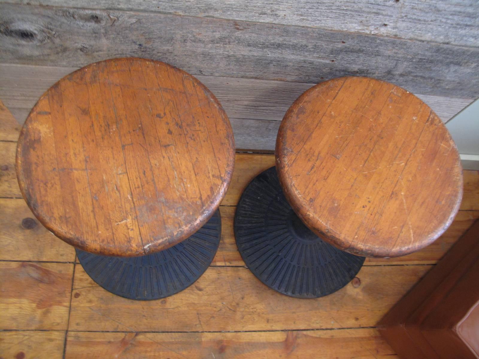 Pair of factory stools with patterned iron bases, and maple seats.
Bases have dark blue worn paint.

Measures: Base diameter: 17.5