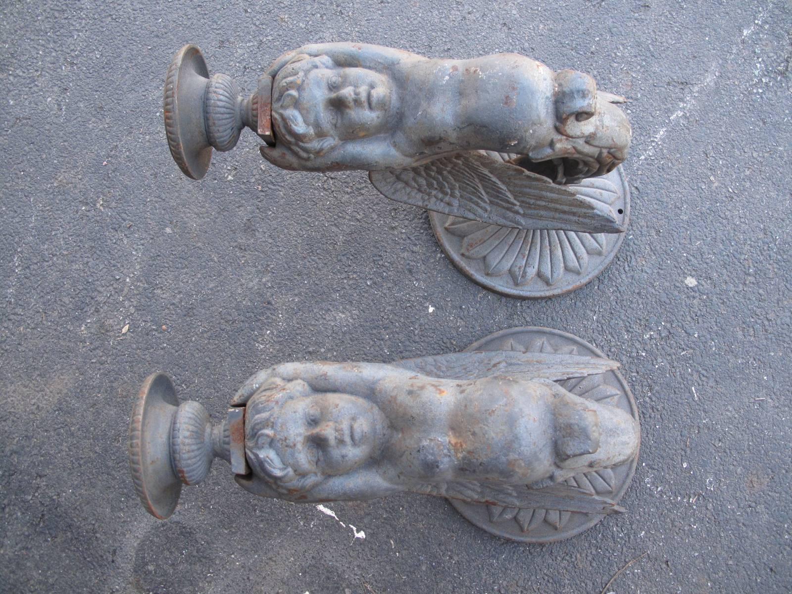 Two monumental winged putti, each holding a petite urn. Cast iron. Likely late 20th century production.