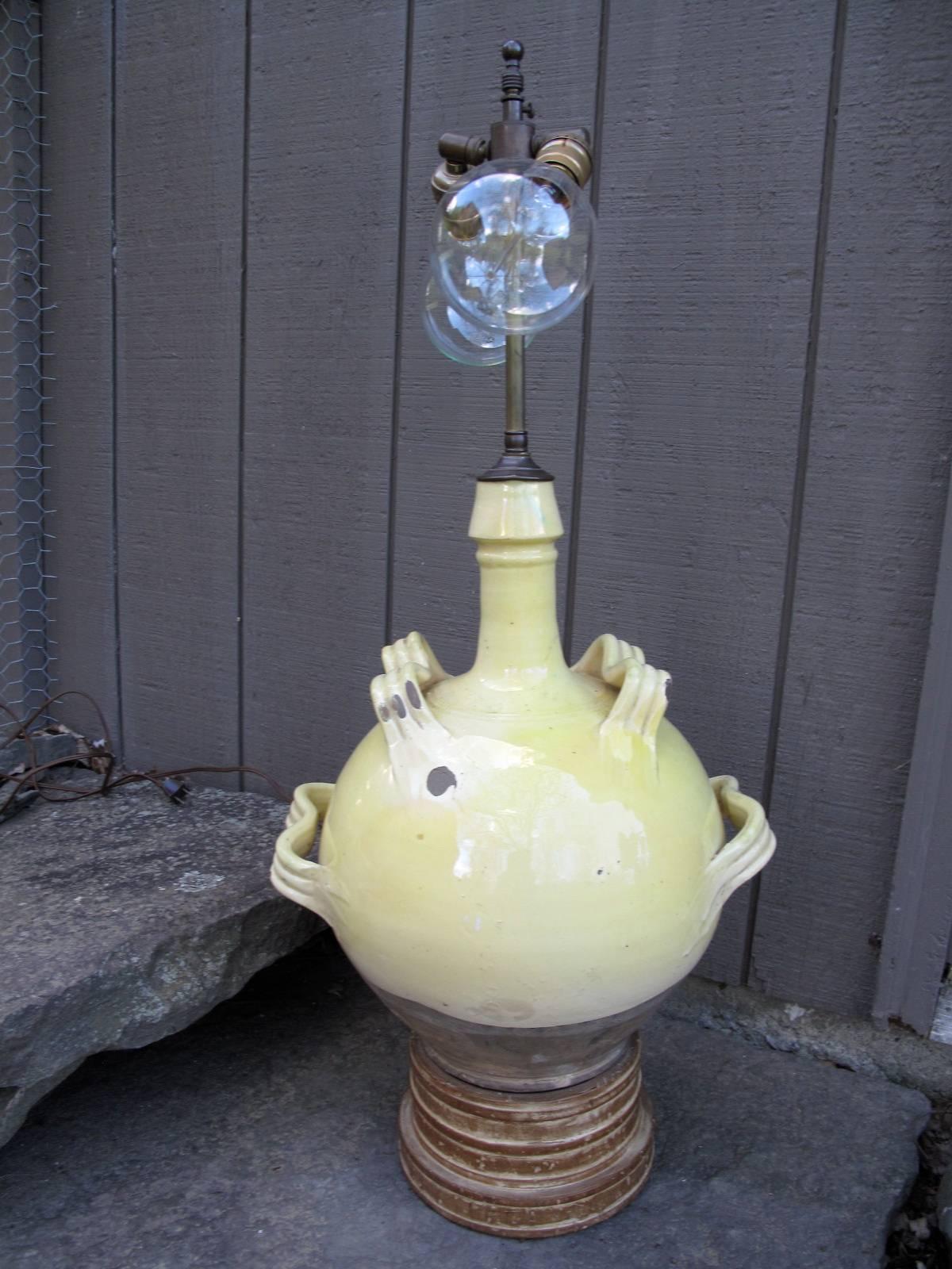 Lemon yellow glazed terra cotta vessel. 20th century conversion to double socket table lamp on graduated wood plinth.