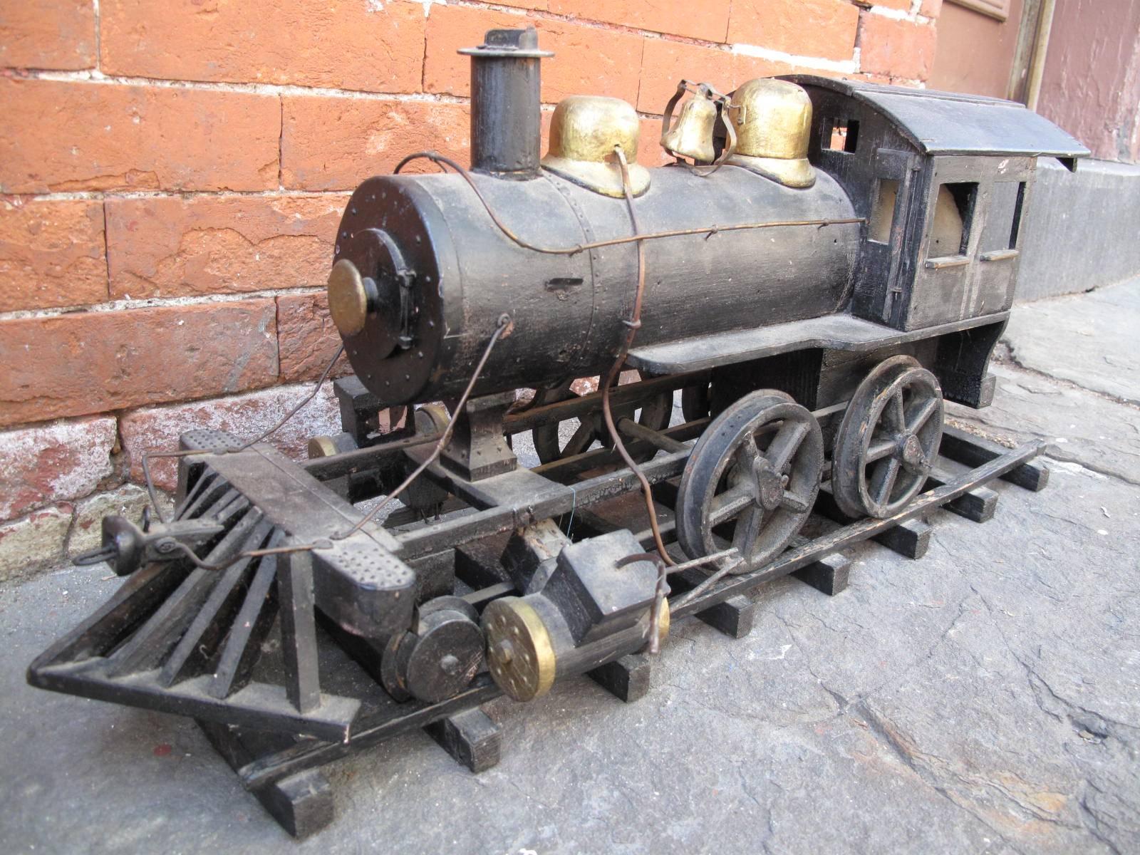 Model of early 20th century American steam engine on separate tracks. All wood construction in black and gold paint. No apparent signature of artist or maker.