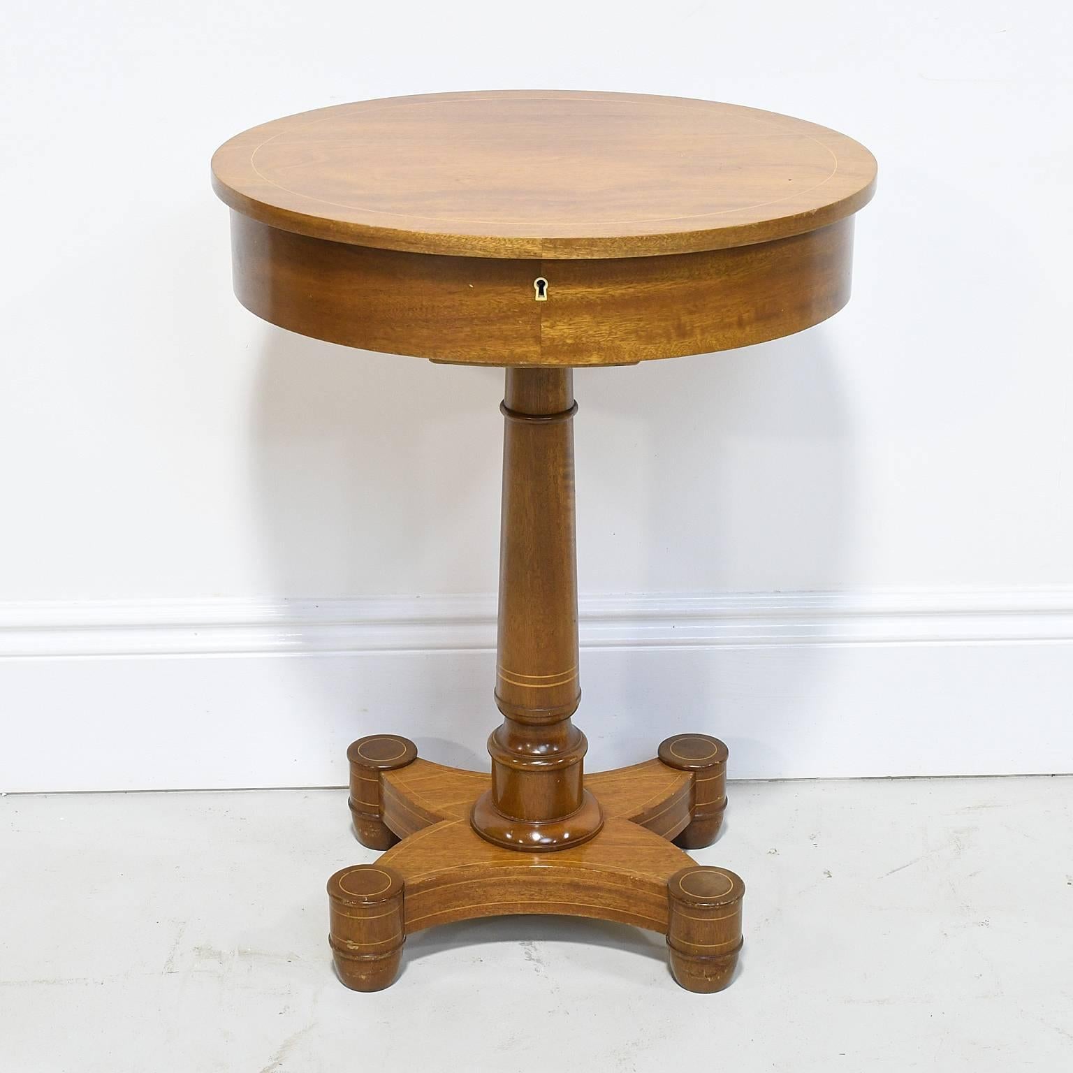 An exceptional small work or sewing table with oval top on turned column resting on quatre-form base in a light-colored mahogany with fine line inlays. Top opens to an interior with divided compartments. Scandinavia, circa 1890-1900. 

Measures: 21